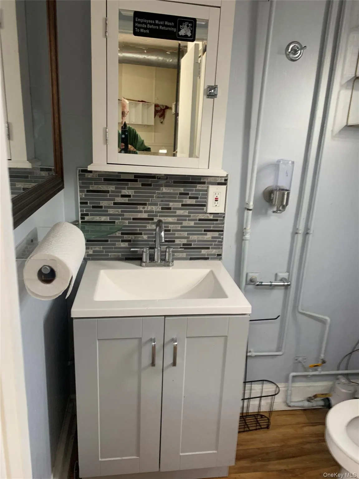 Bathroom with wood finished floors, vanity, and tasteful backsplash Bathroom with wood finished floors, vanity, and tasteful backsplash