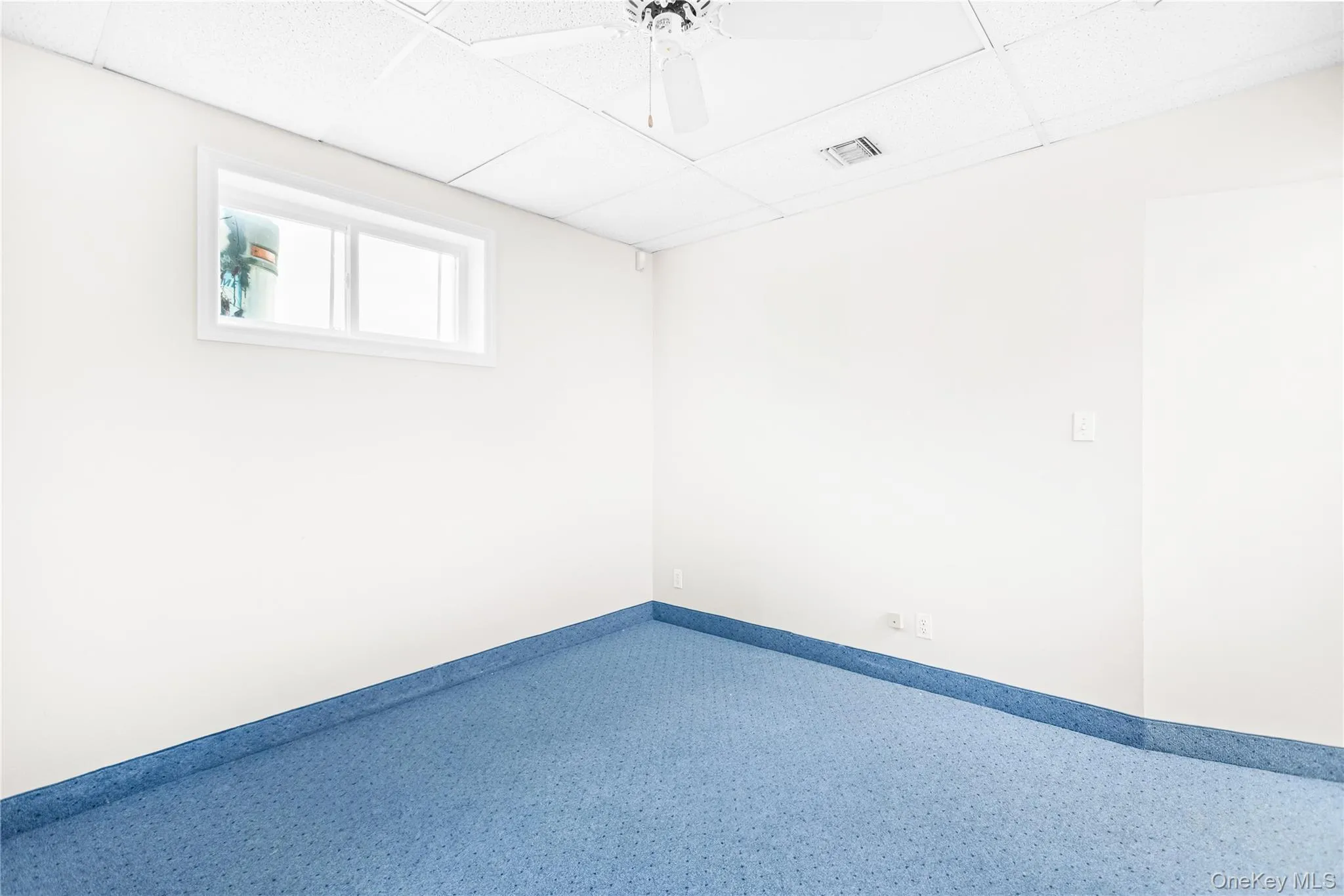 Office with a paneled ceiling and ceiling fan Office with a paneled ceiling and ceiling fan