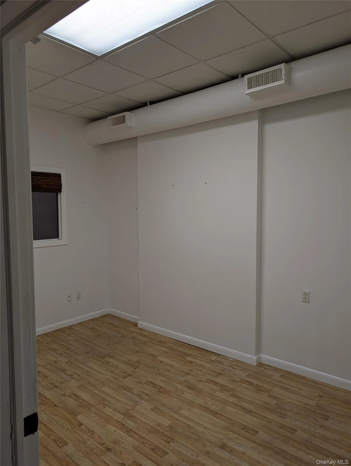 Private office featuring light wood-style flooring and a drop ceiling Private office featuring light wood-style flooring and a drop ceiling