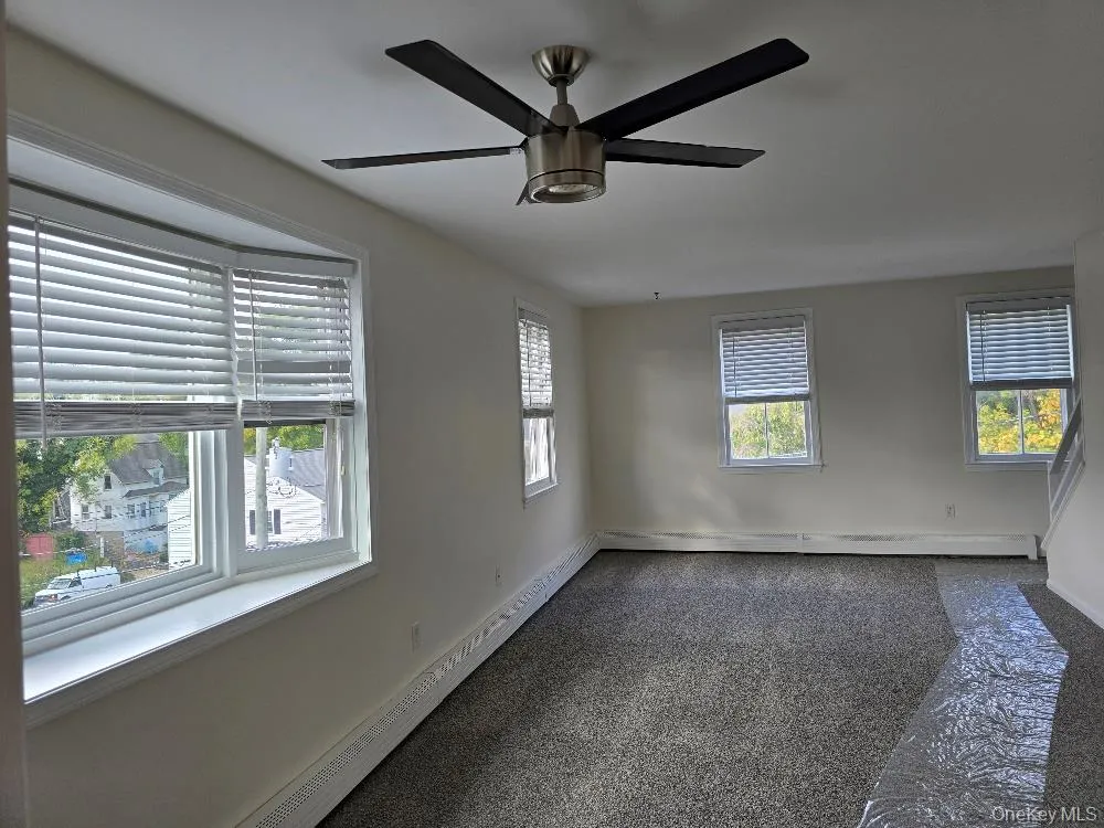 Spare room with baseboard heating, a ceiling fan, and a baseboard radiator Spare room with baseboard heating, a ceiling fan, and a baseboard radiator