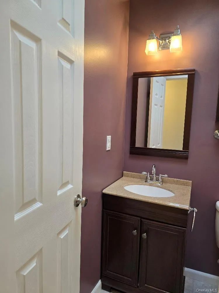 Half bathroom featuring vanity and toilet Half bathroom featuring vanity and toilet