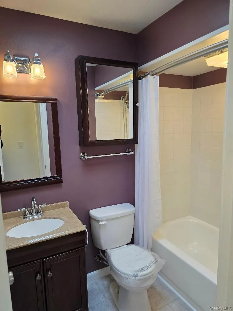 Full bathroom featuring vanity and shower / bath combo with shower curtain Full bathroom featuring vanity and shower / bath combo with shower curtain