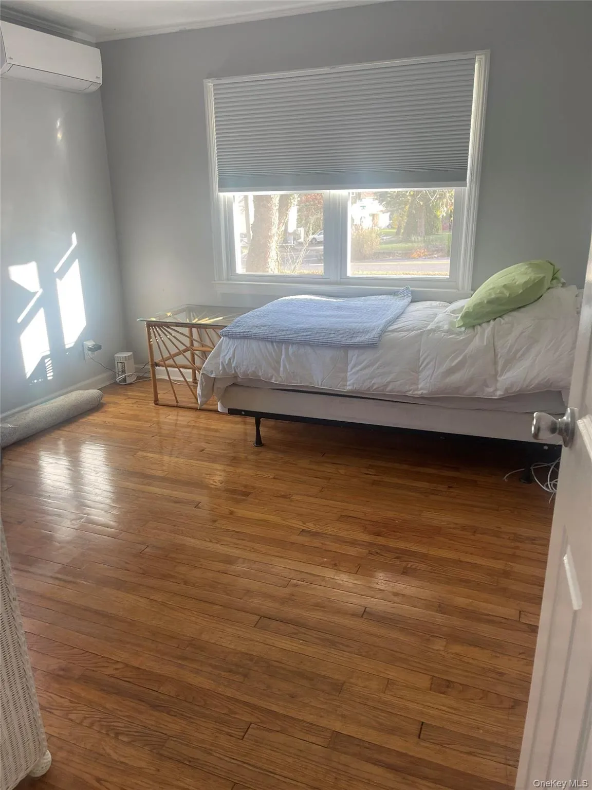 Bedroom featuring hardwood / wood-style flooring and a wall mounted AC Bedroom featuring hardwood / wood-style flooring and a wall mounted AC
