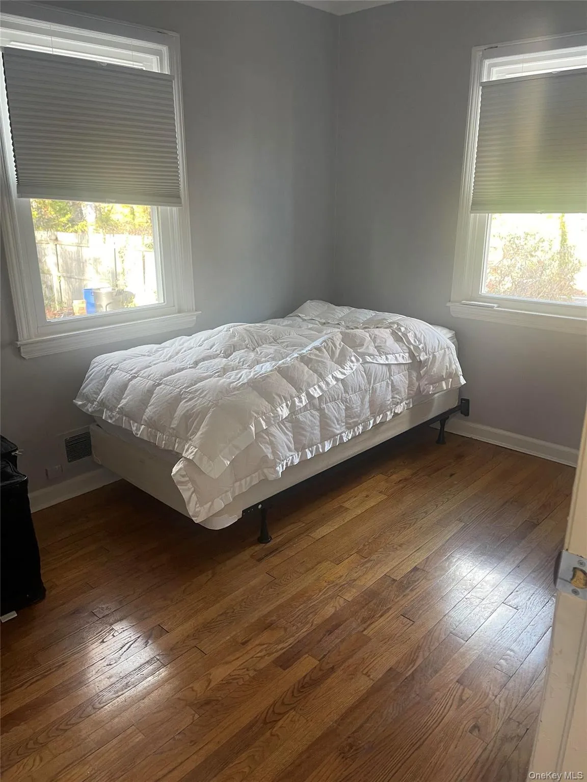 Bedroom with hardwood / wood-style flooring and baseboards Bedroom with hardwood / wood-style flooring and baseboards