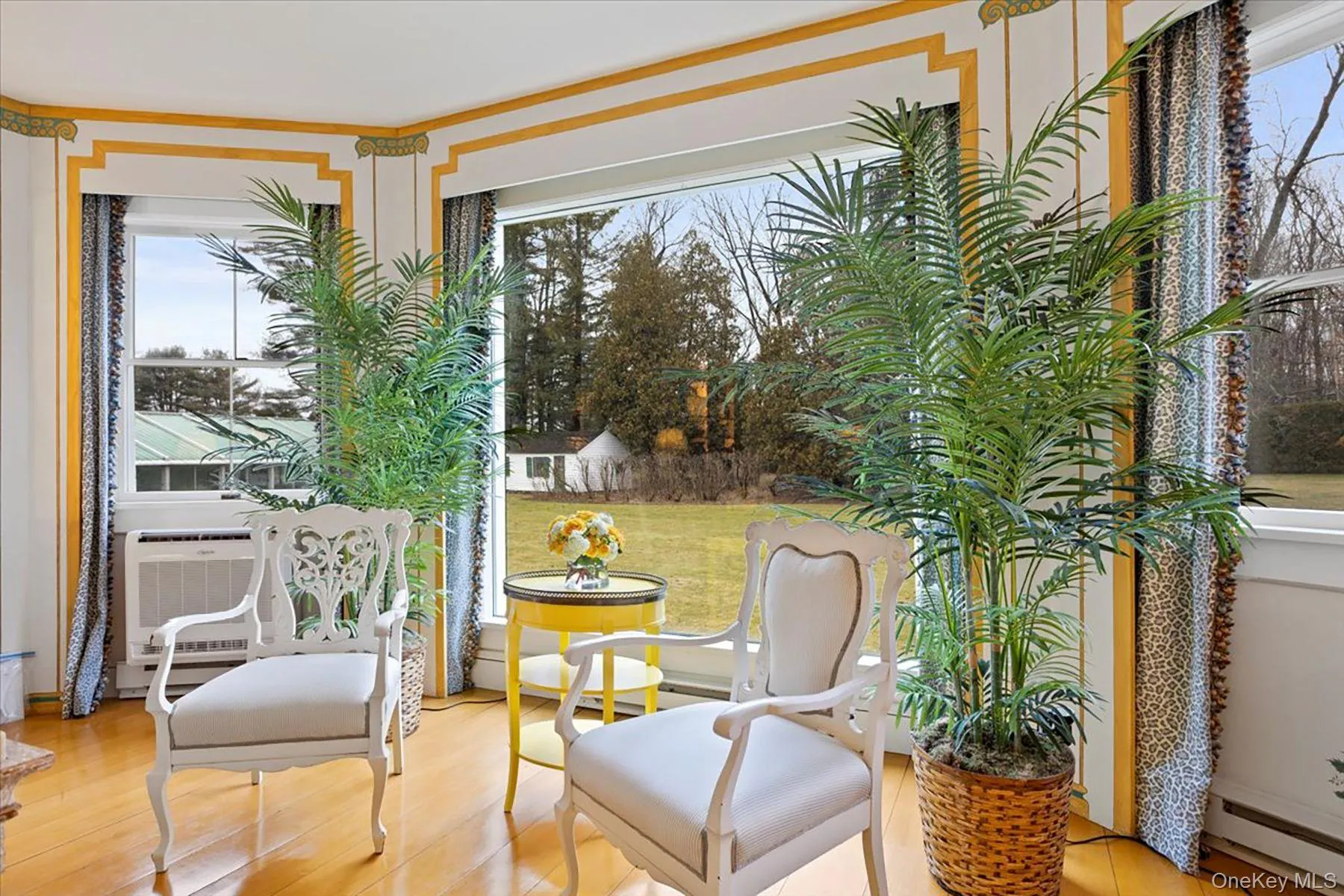 Sitting room featuring plenty of natural light, light wood finished floors, and a baseboard heating unit Sitting room featuring plenty of natural light, light wood finished floors, and a baseboard heating unit