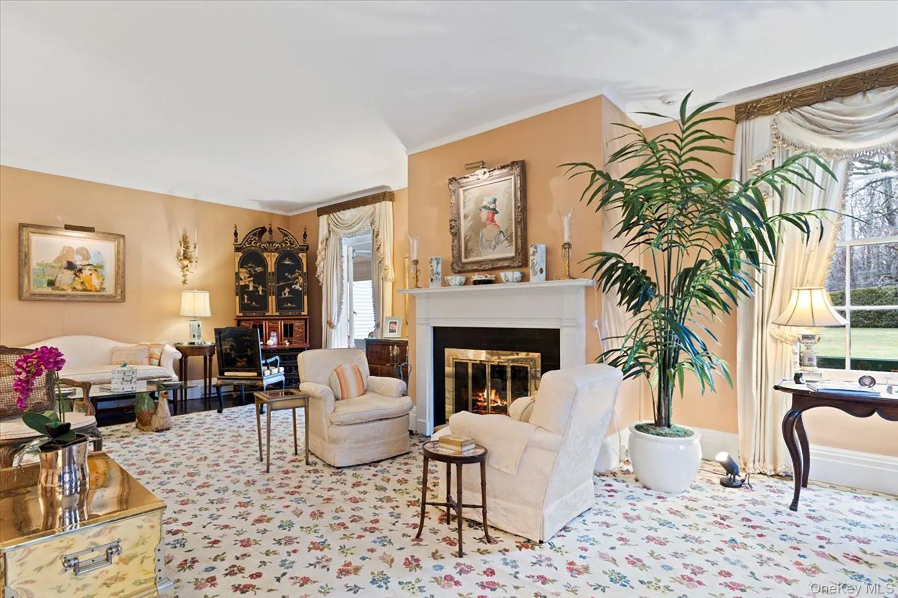 Living area featuring a glass covered fireplace, ornamental molding, and carpet Living area featuring a glass covered fireplace, ornamental molding, and carpet