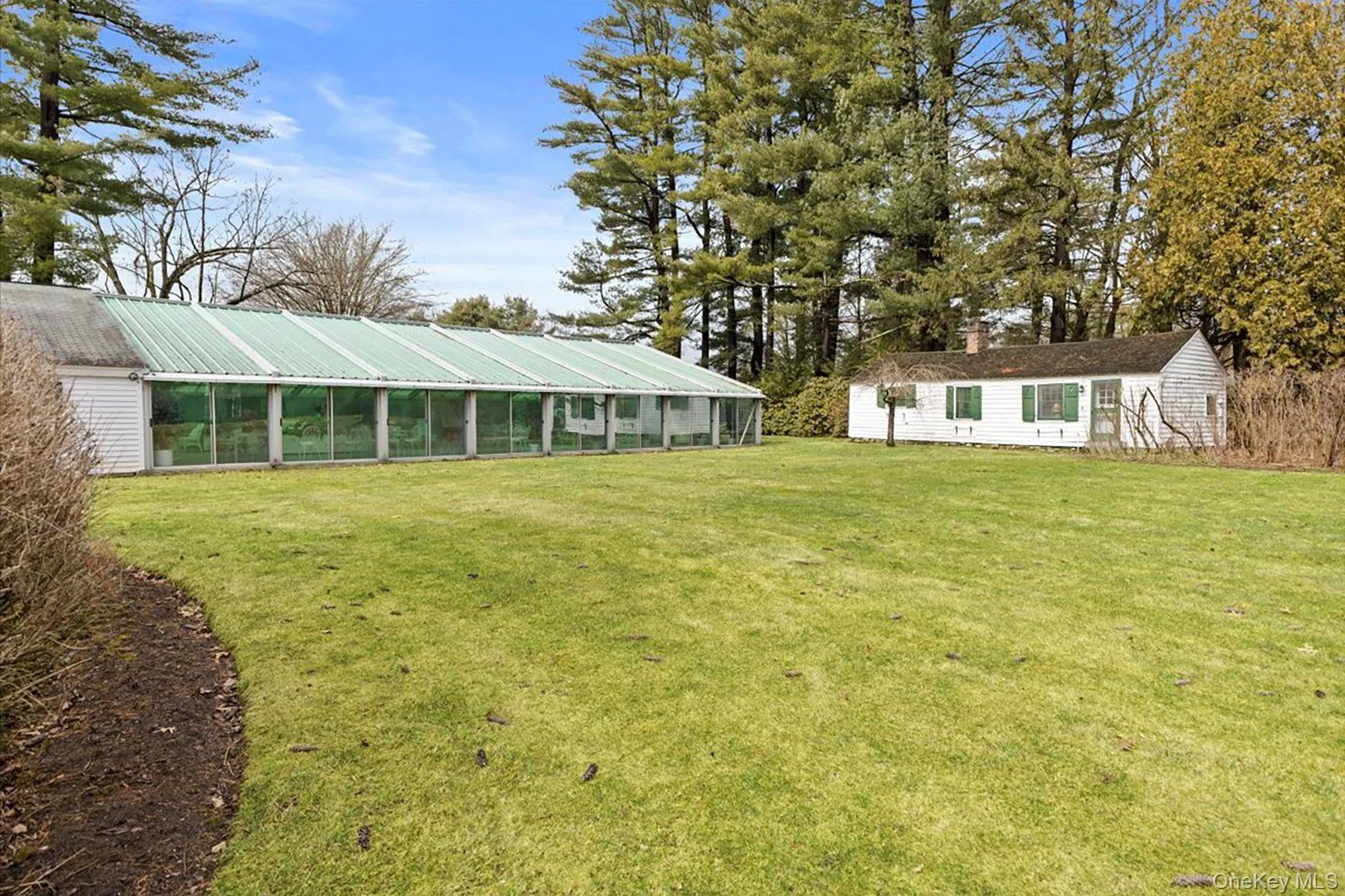 View of grassy yard with a sunroom and an outdoor structure View of grassy yard with a sunroom and an outdoor structure