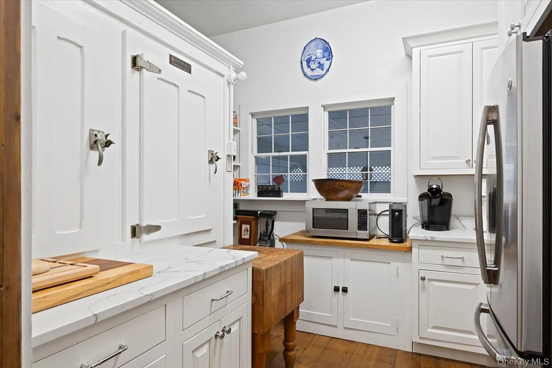 Kitchen with appliances with stainless steel finishes, light stone countertops, and white cabinets Kitchen with appliances with stainless steel finishes, light stone countertops, and white cabinets
