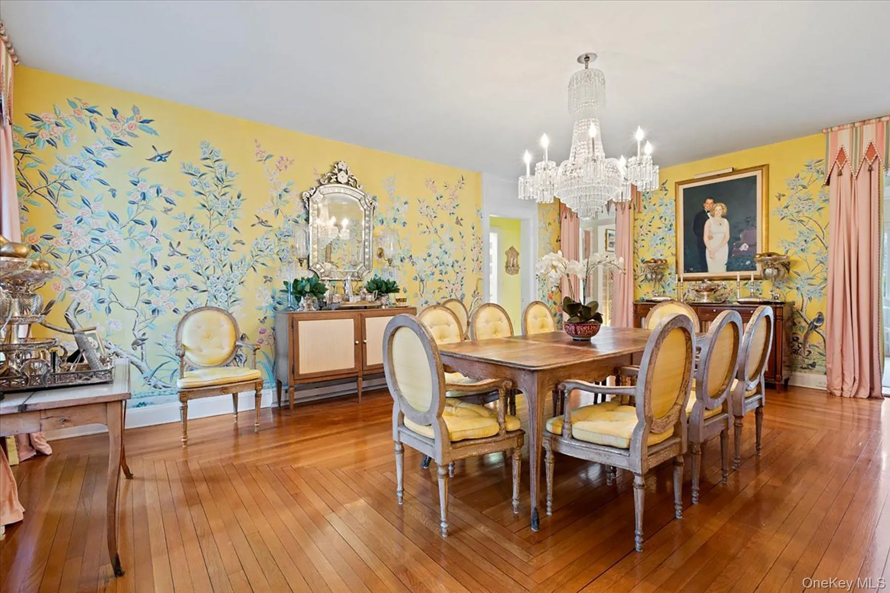 Dining area with hardwood / wood-style floors, wallpapered walls, and a chandelier Dining area with hardwood / wood-style floors, wallpapered walls, and a chandelier