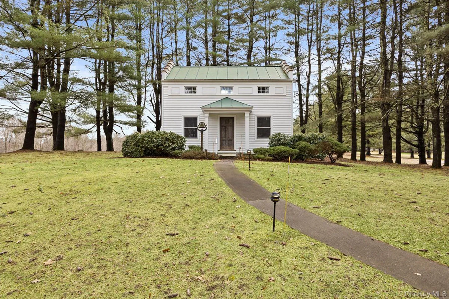 View of front of home featuring a standing seam roof, a front yard, a metal roof, and a chimney View of front of home featuring a standing seam roof, a front yard, a metal roof, and a chimney