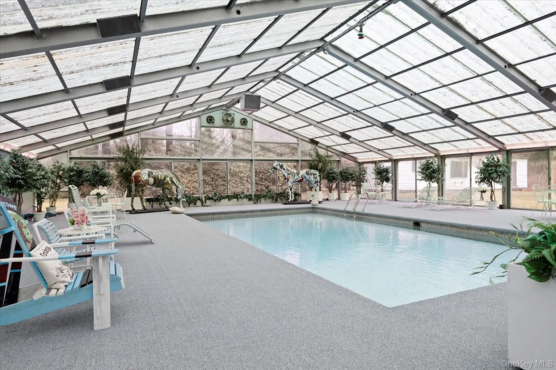 Indoor pool with glass enclosure and a patio area Indoor pool with glass enclosure and a patio area