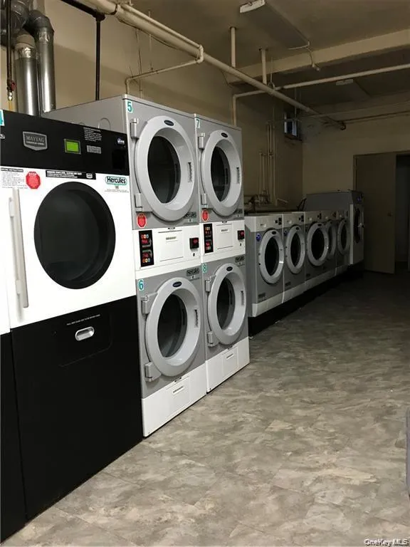 Shared laundry room with stacked washer / drying machine and separate washer and dryer Shared laundry room with stacked washer / drying machine and separate washer and dryer