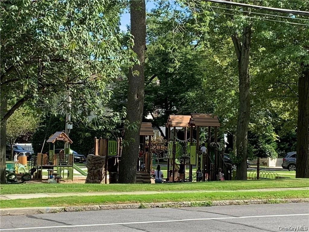 Community play area featuring a yard Community play area featuring a yard