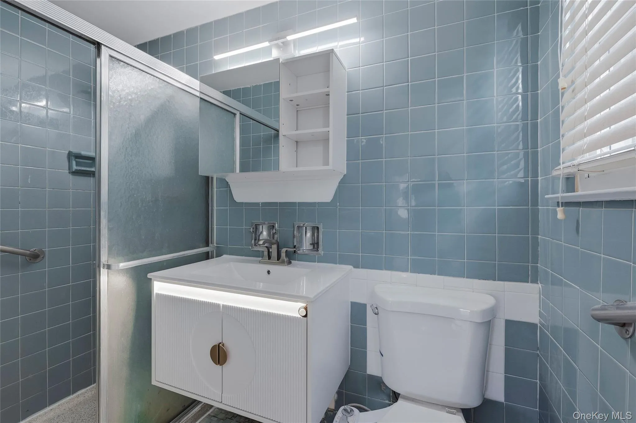 Bathroom featuring tile walls, a shower stall, and vanity Bathroom featuring tile walls, a shower stall, and vanity