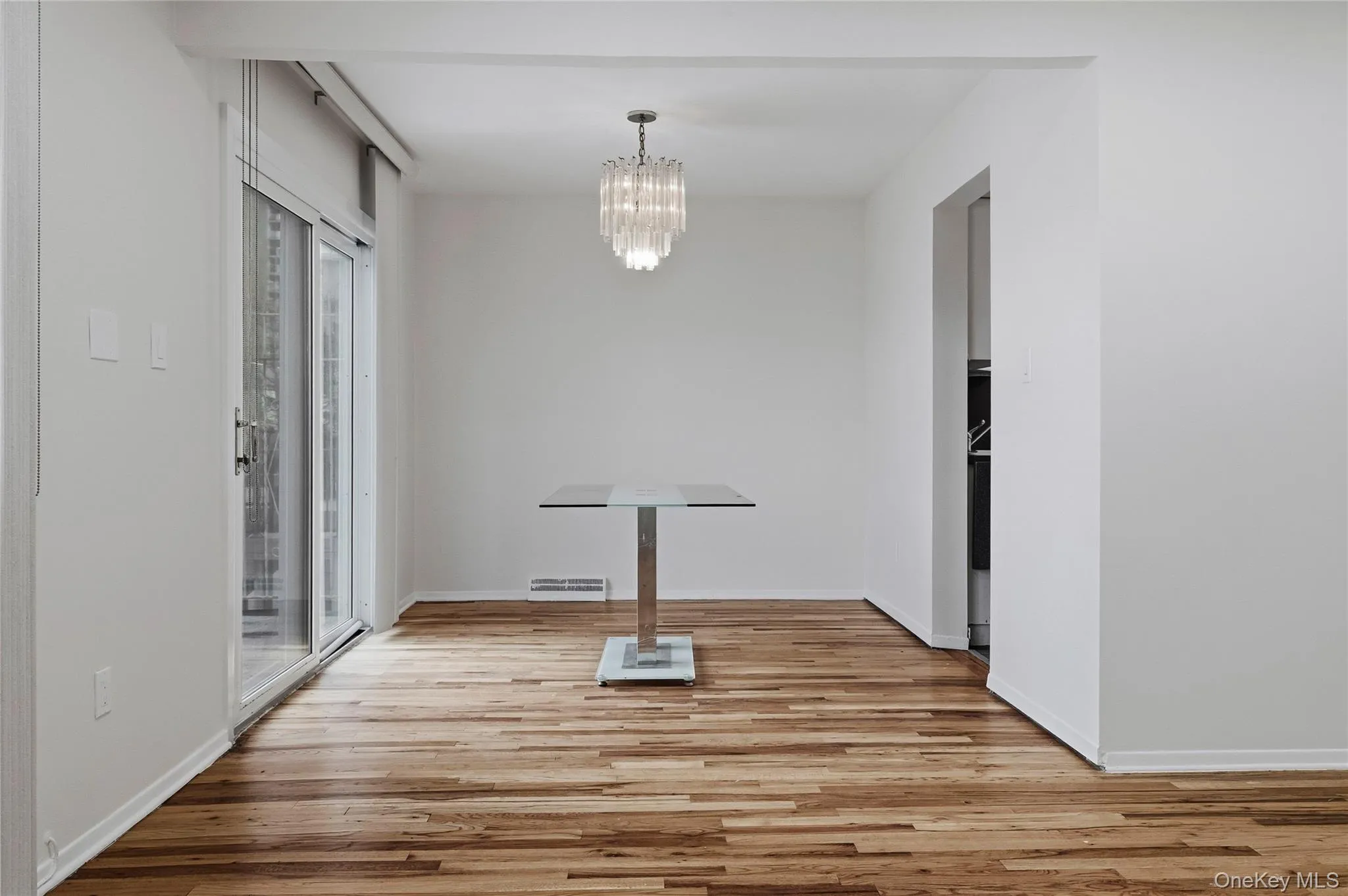 Unfurnished dining area featuring light wood-style flooring and a chandelier Unfurnished dining area featuring light wood-style flooring and a chandelier