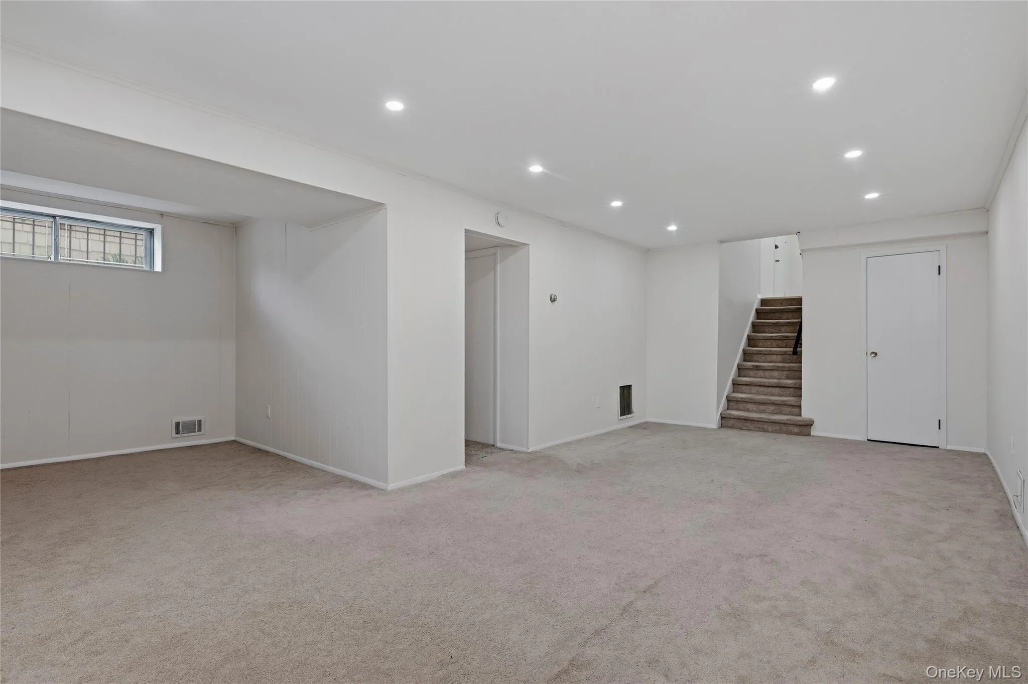 Below grade area featuring light colored carpet, recessed lighting, and stairway Below grade area featuring light colored carpet, recessed lighting, and stairway