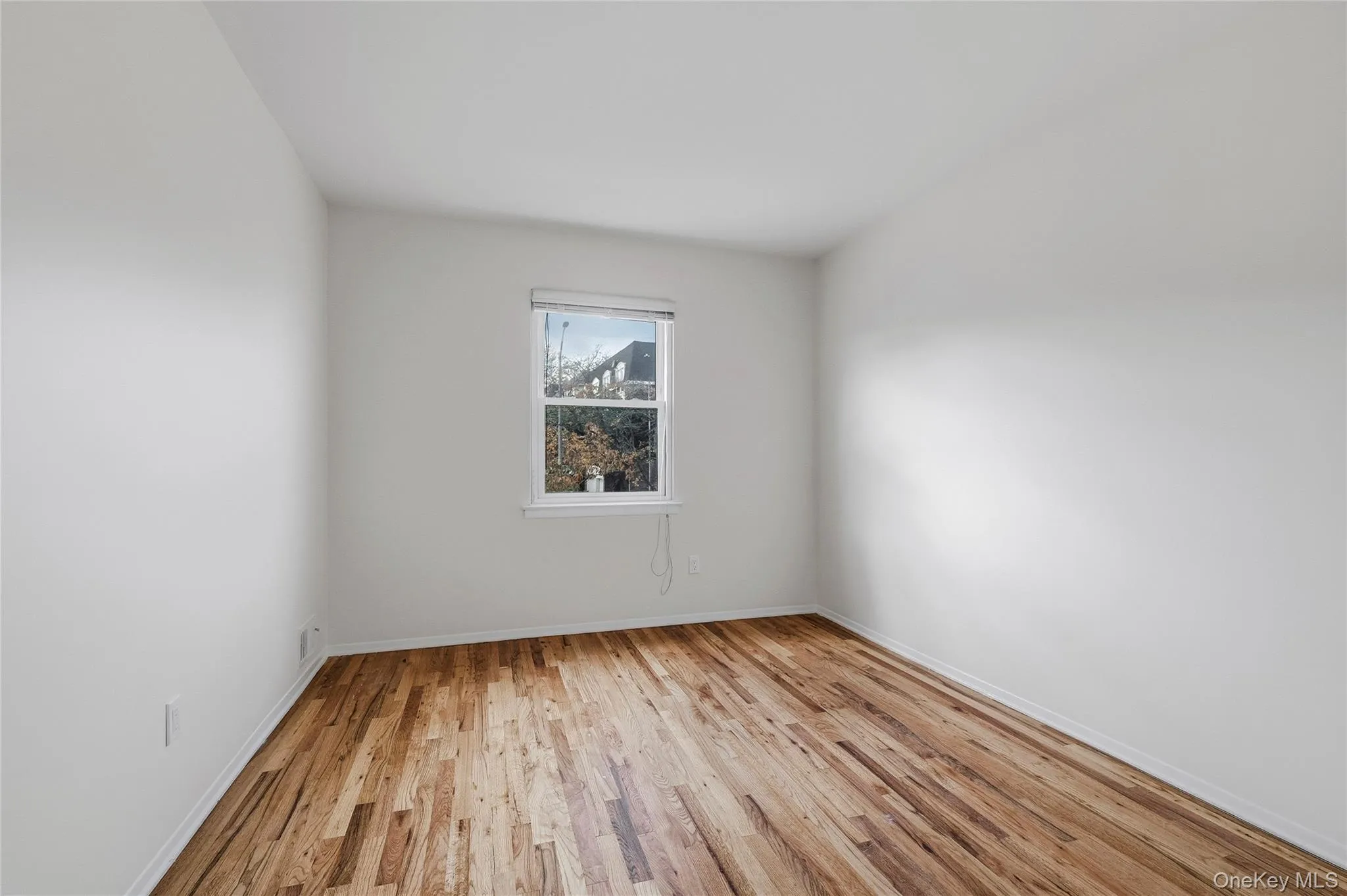 Spare room with light wood-style floors and baseboards Spare room with light wood-style floors and baseboards