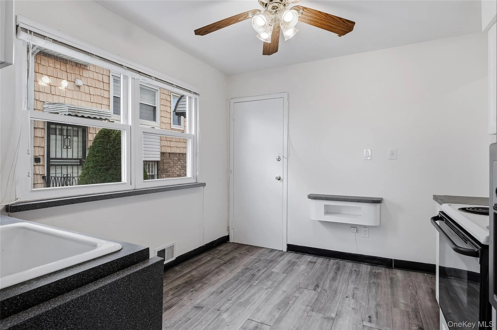 Kitchen featuring light wood-style flooring, black electric range, dark countertops, and a ceiling fan Kitchen featuring light wood-style flooring, black electric range, dark countertops, and a ceiling fan