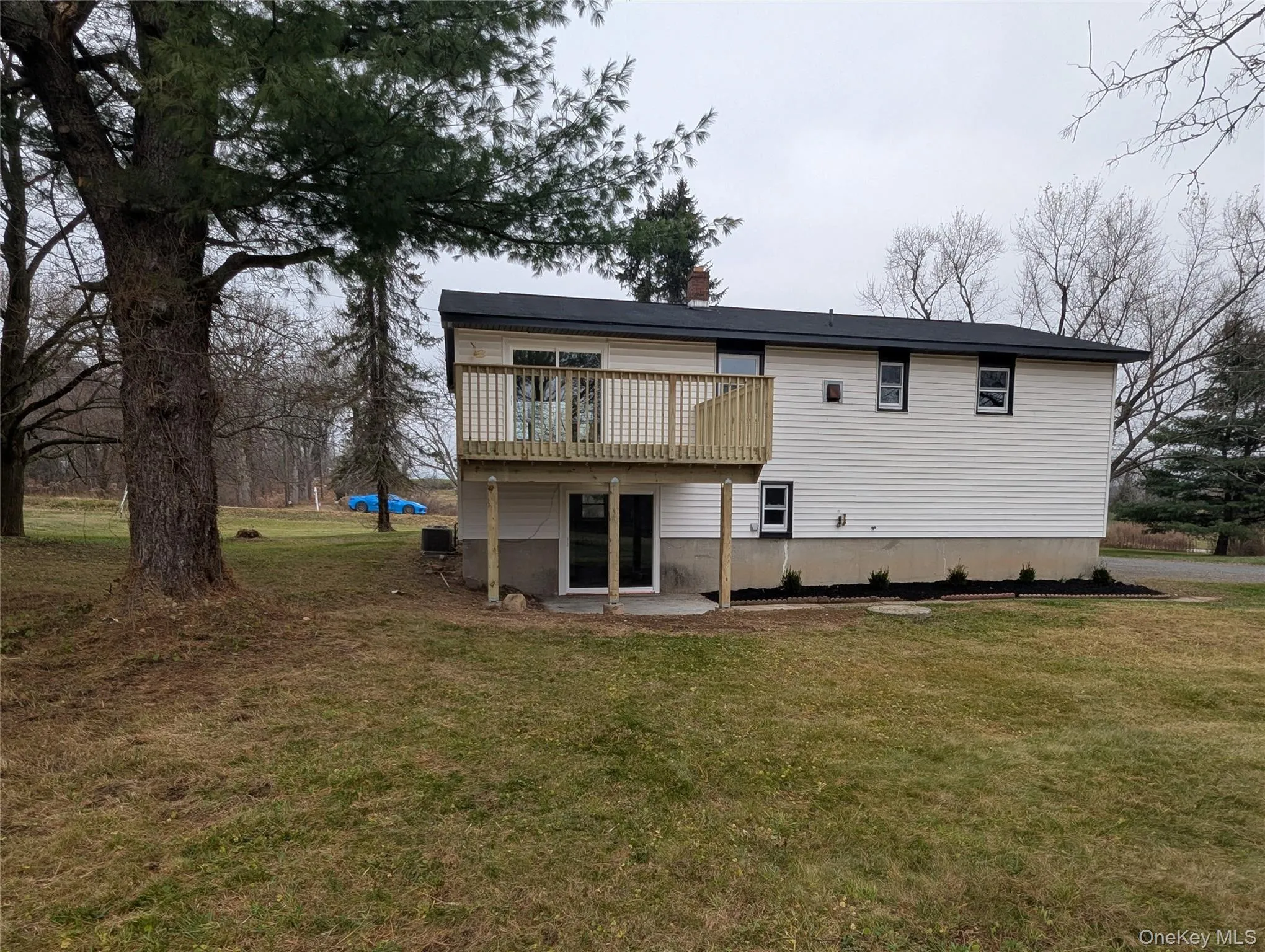 Back of house with a yard, a patio, and a wooden deck Back of house with a yard, a patio, and a wooden deck