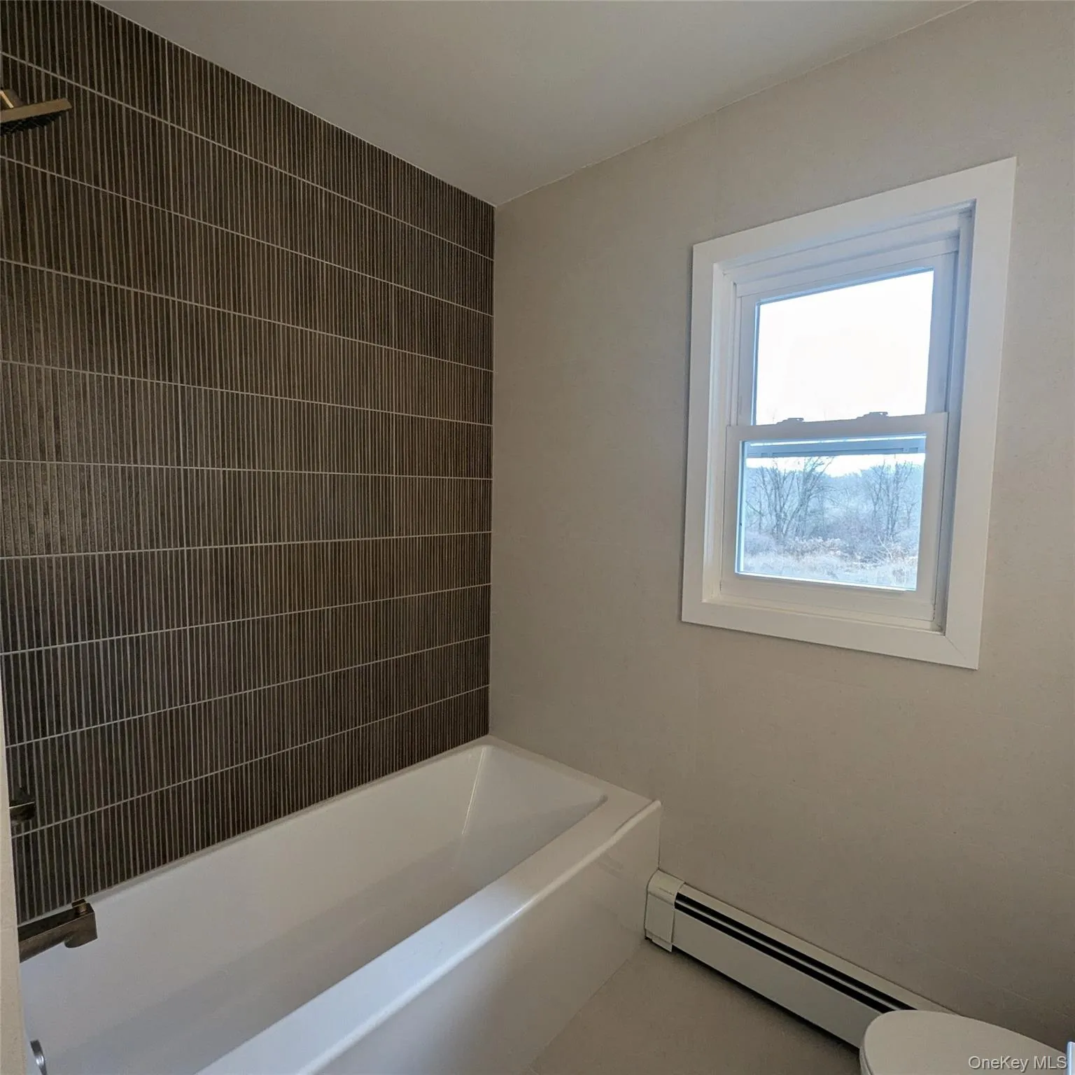 Bathroom with a baseboard heating unit and tile patterned floors Bathroom with a baseboard heating unit and tile patterned floors