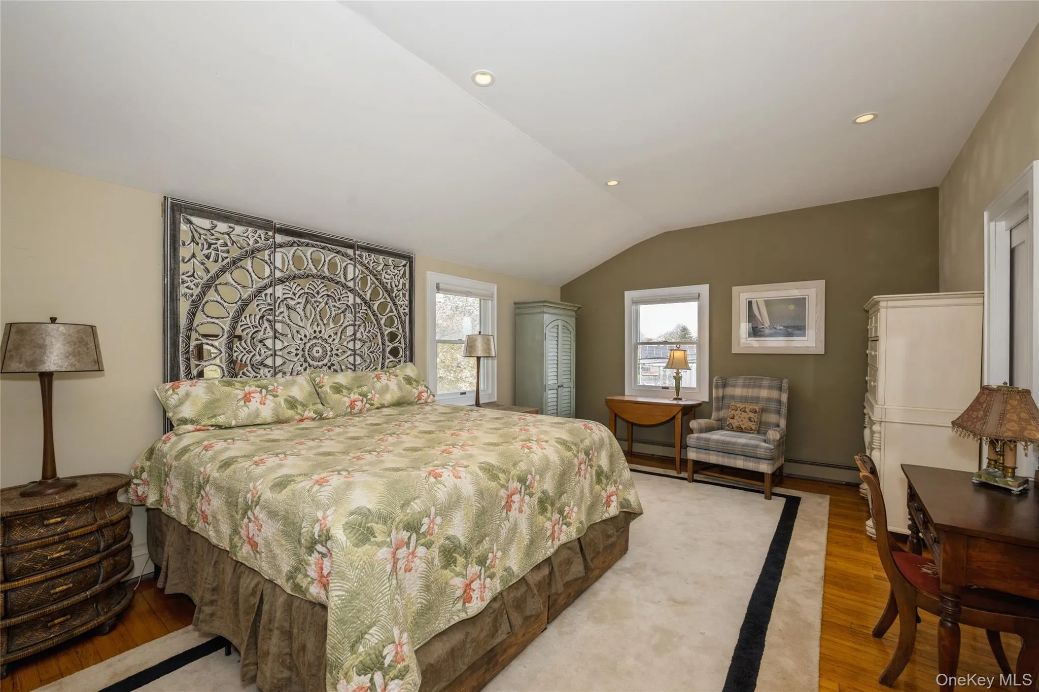 Bedroom featuring lofted ceiling, recessed lighting, wood finished floors, and baseboard heating Bedroom featuring lofted ceiling, recessed lighting, wood finished floors, and baseboard heating
