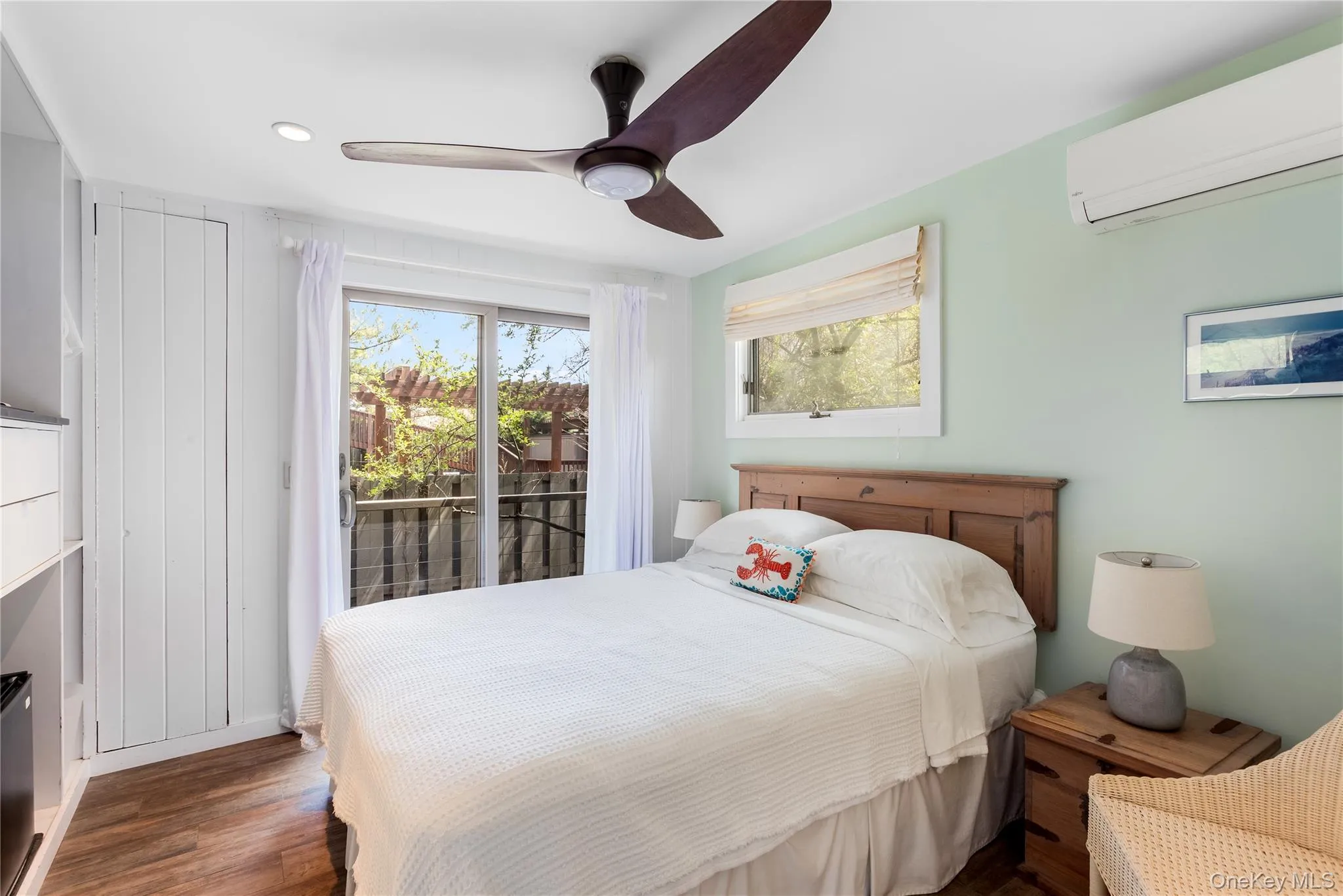 Bedroom featuring a wall mounted AC, access to exterior, dark wood-type flooring, and ceiling fan Bedroom featuring a wall mounted AC, access to exterior, dark wood-type flooring, and ceiling fan