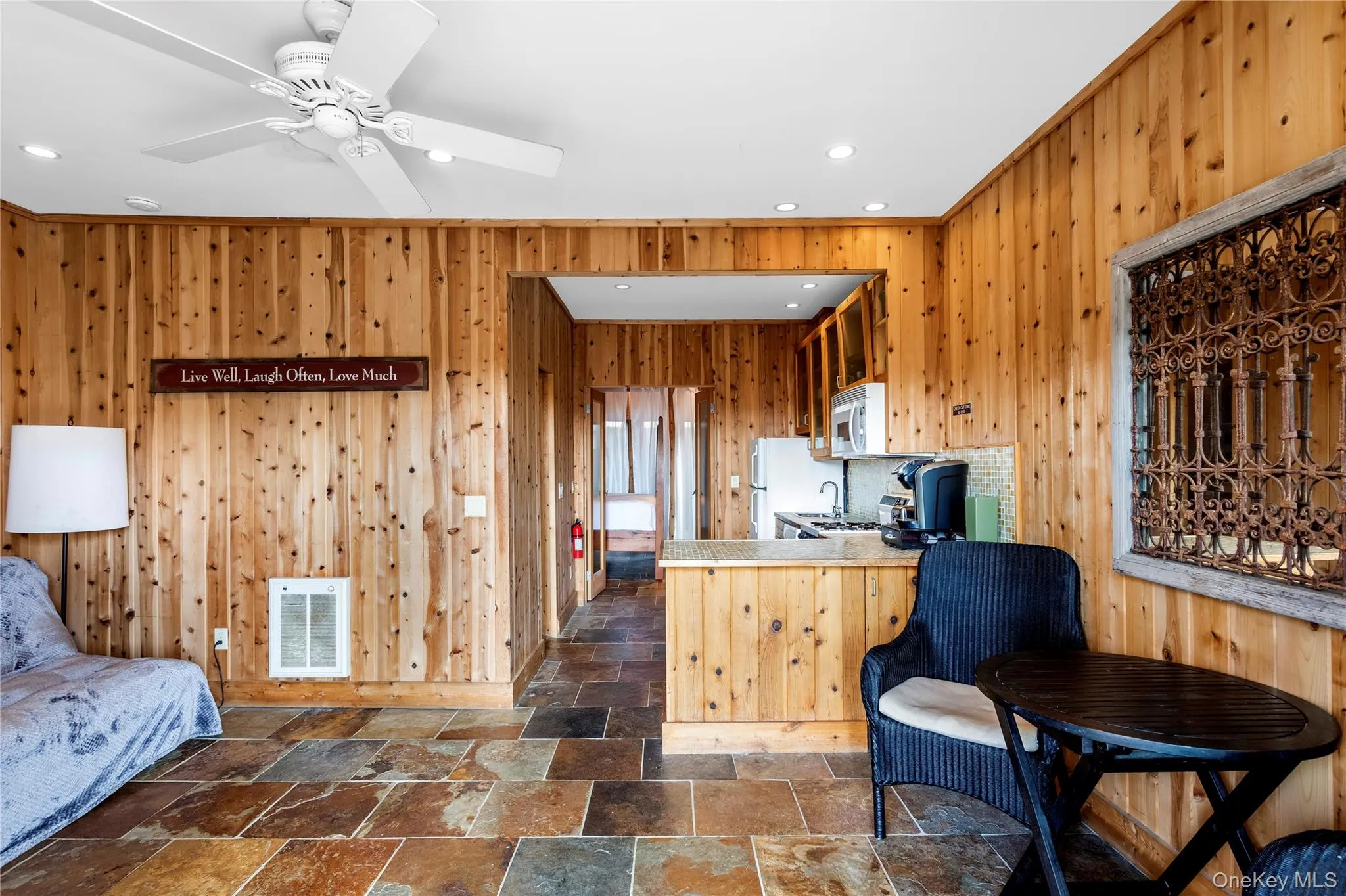 Kitchen with wooden walls, heating unit, stone tile flooring, recessed lighting, and a peninsula Kitchen with wooden walls, heating unit, stone tile flooring, recessed lighting, and a peninsula