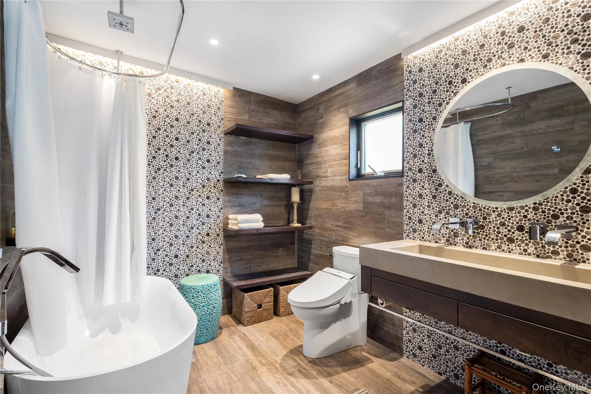 Bathroom featuring tile walls, vanity, light wood finished floors, a shower with curtain, and a chandelier Bathroom featuring tile walls, vanity, light wood finished floors, a shower with curtain, and a chandelier