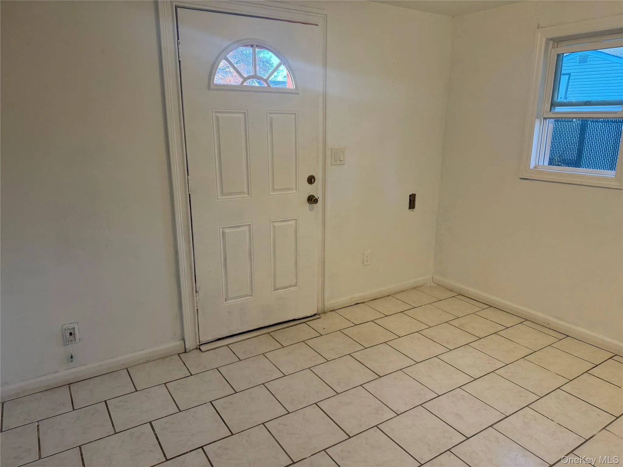 Foyer entrance featuring baseboards and light tile patterned floors Foyer entrance featuring baseboards and light tile patterned floors