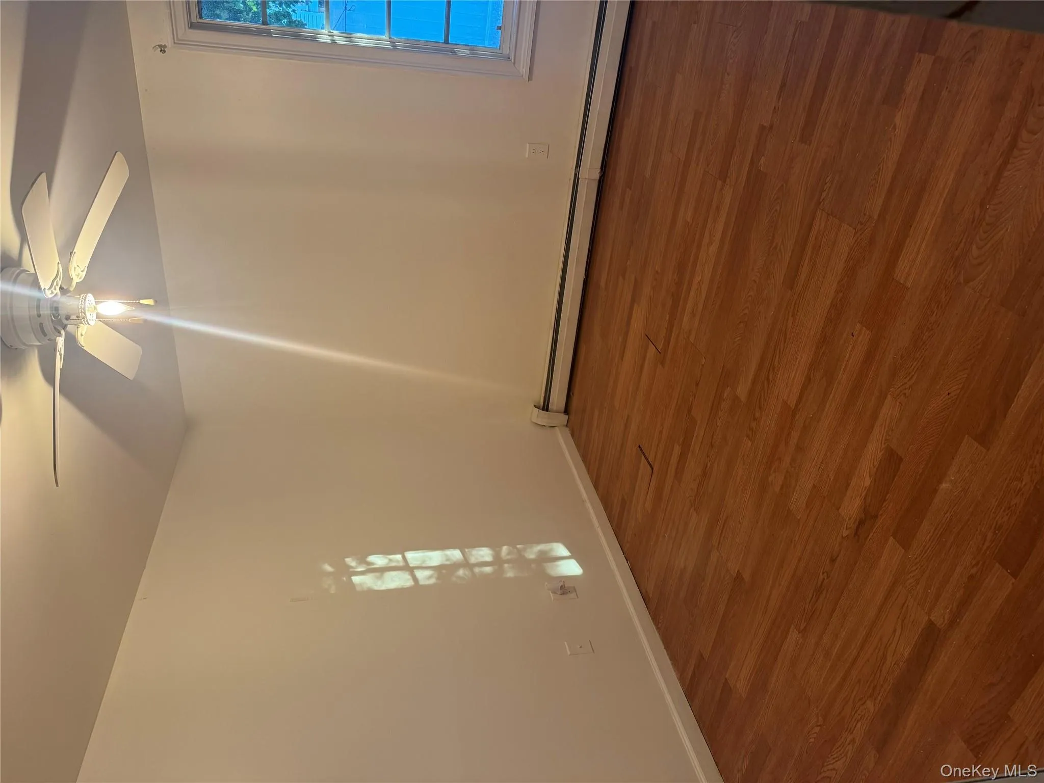 Empty room with dark wood-style floors, baseboard heating, and ceiling fan Empty room with dark wood-style floors, baseboard heating, and ceiling fan