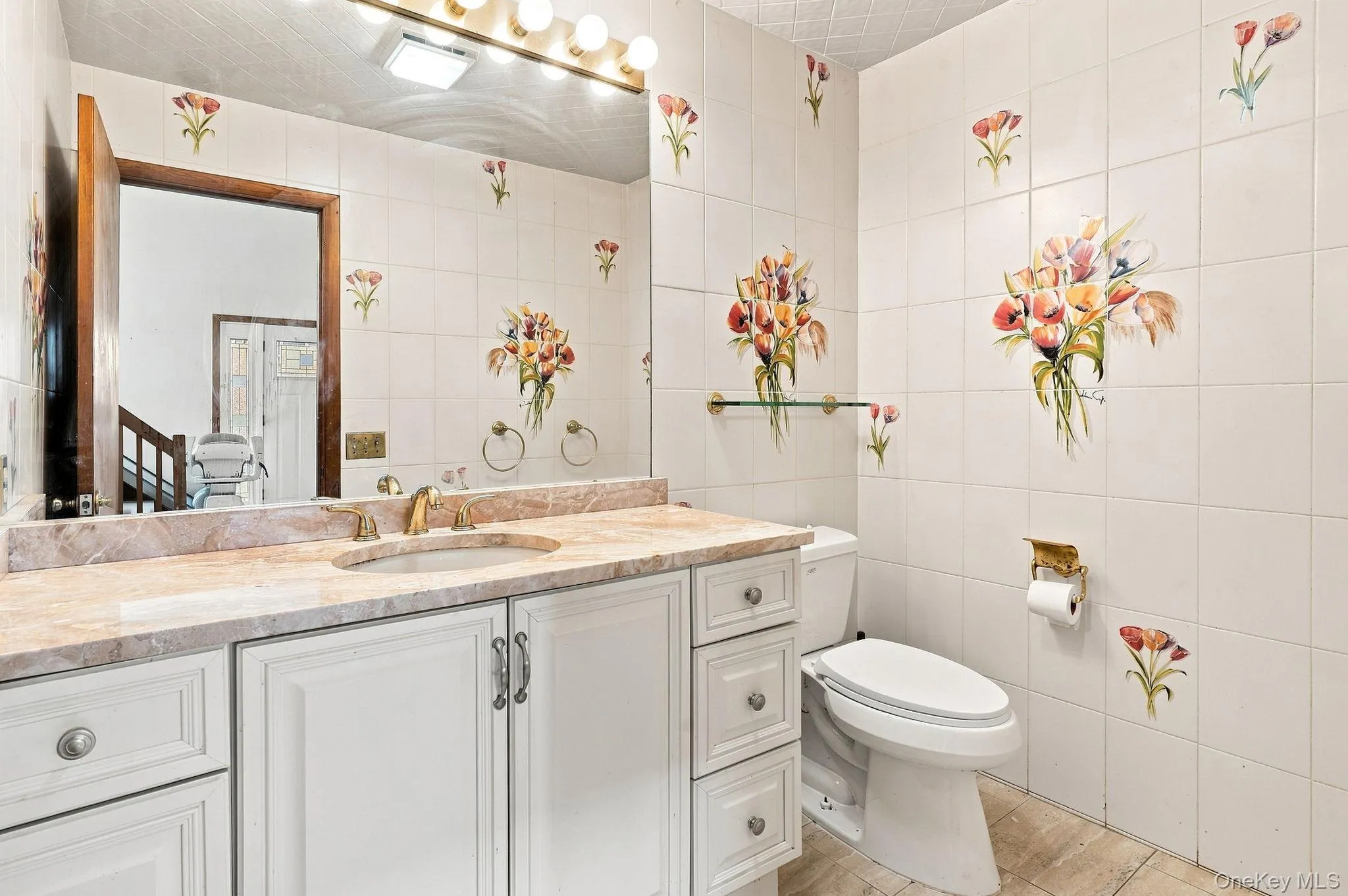 Vanity with a polished stone countertop, integrated sink, and gold-finish faucet Vanity with a polished stone countertop, integrated sink, and gold-finish faucet