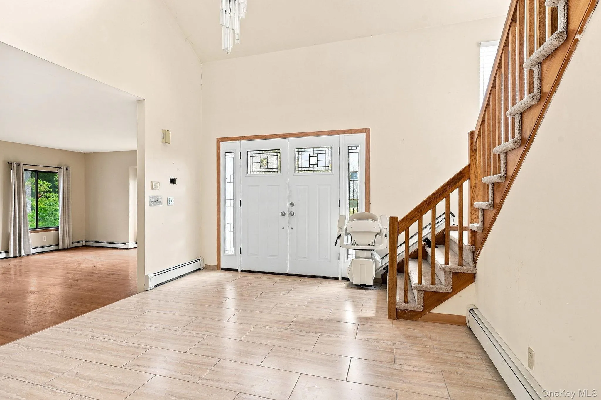 Foyer featuring tile flooring, vaulted ceiling, and double entry doors with decorative glass Foyer featuring tile flooring, vaulted ceiling, and double entry doors with decorative glass
