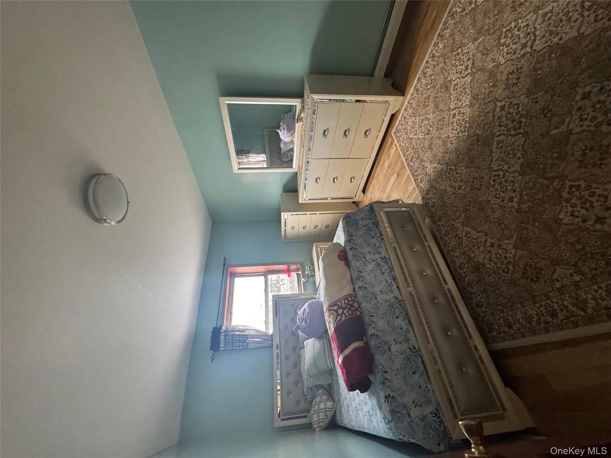 Bedroom featuring light wood finished floors and a baseboard radiator Bedroom featuring light wood finished floors and a baseboard radiator