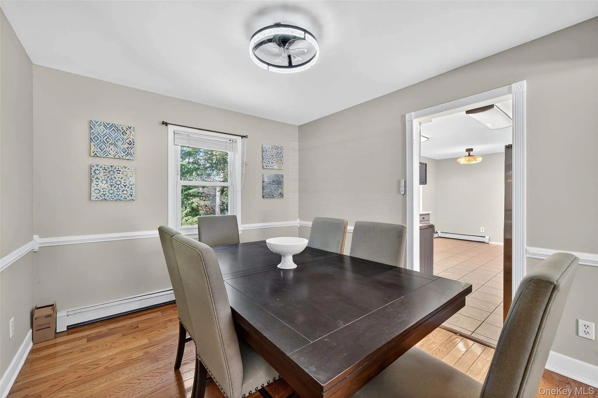 Dining space featuring a baseboard heating unit, a baseboard radiator, and light wood finished floors Dining space featuring a baseboard heating unit, a baseboard radiator, and light wood finished floors