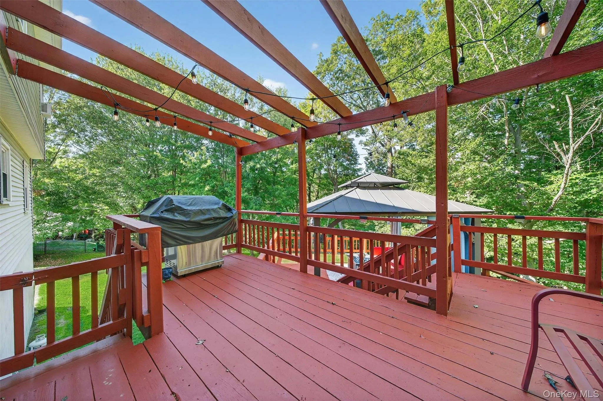Wooden terrace featuring area for grilling and a gazebo Wooden terrace featuring area for grilling and a gazebo