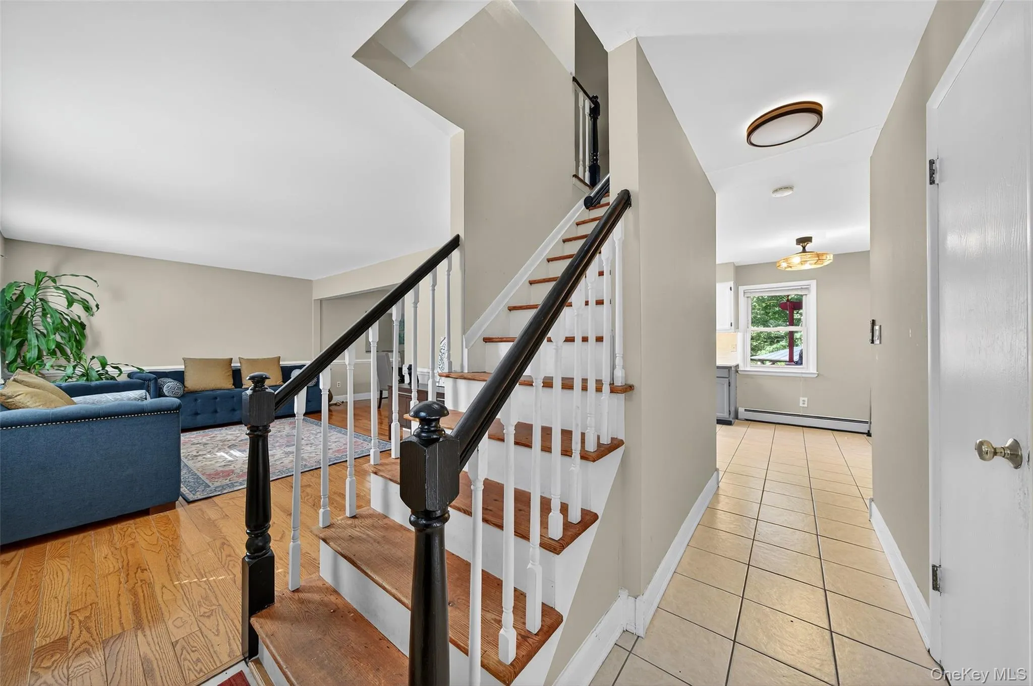 Staircase featuring a baseboard radiator and tile patterned flooring Staircase featuring a baseboard radiator and tile patterned flooring