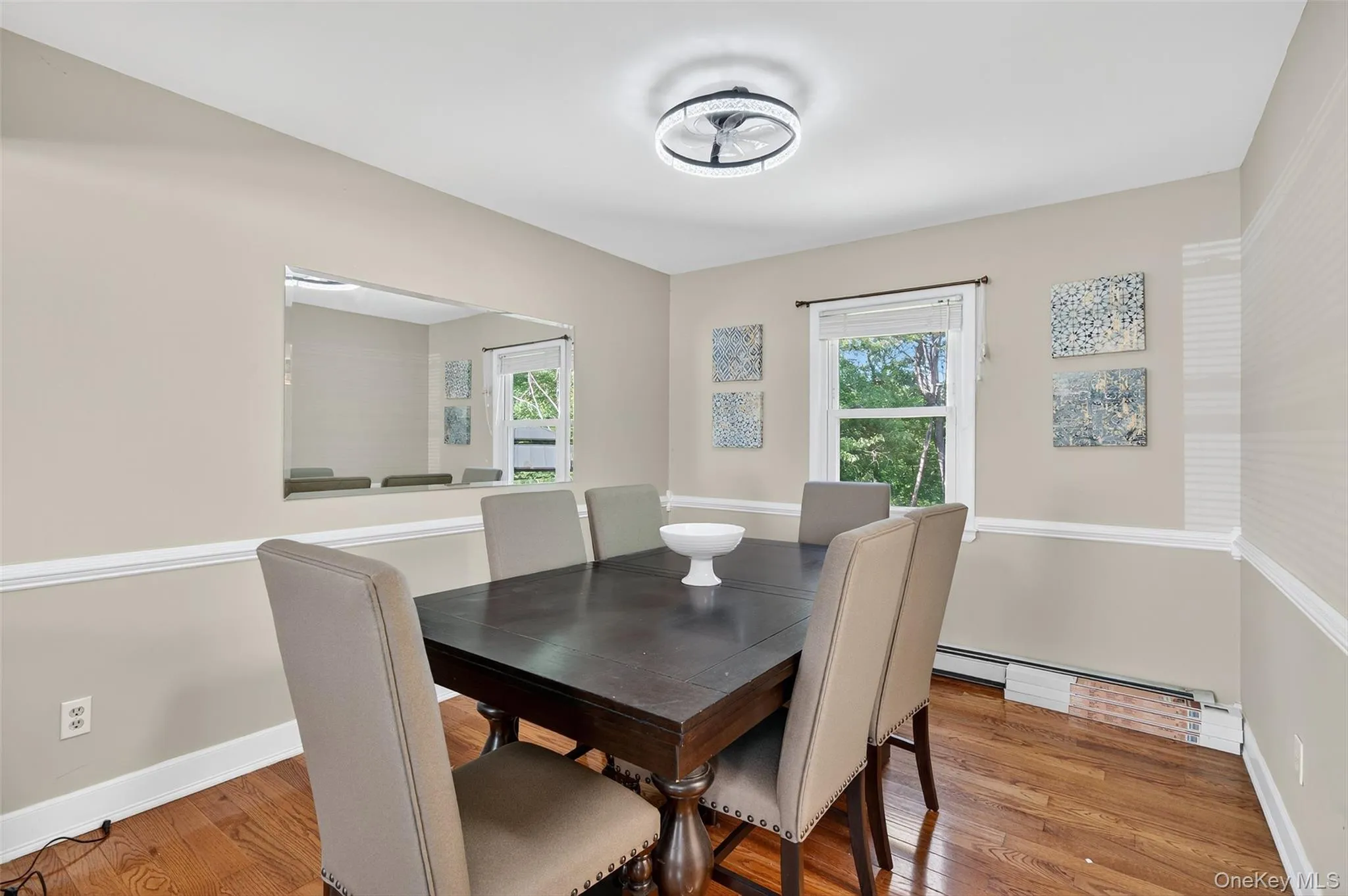 Dining area featuring wood finished floors and a baseboard heating unit Dining area featuring wood finished floors and a baseboard heating unit