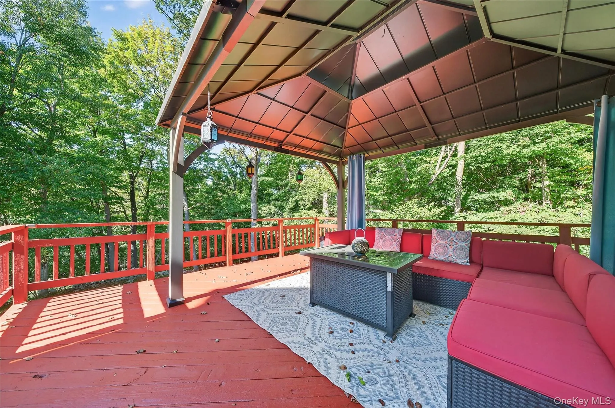 Wooden terrace with an outdoor living space, a gazebo, and view of scattered trees Wooden terrace with an outdoor living space, a gazebo, and view of scattered trees