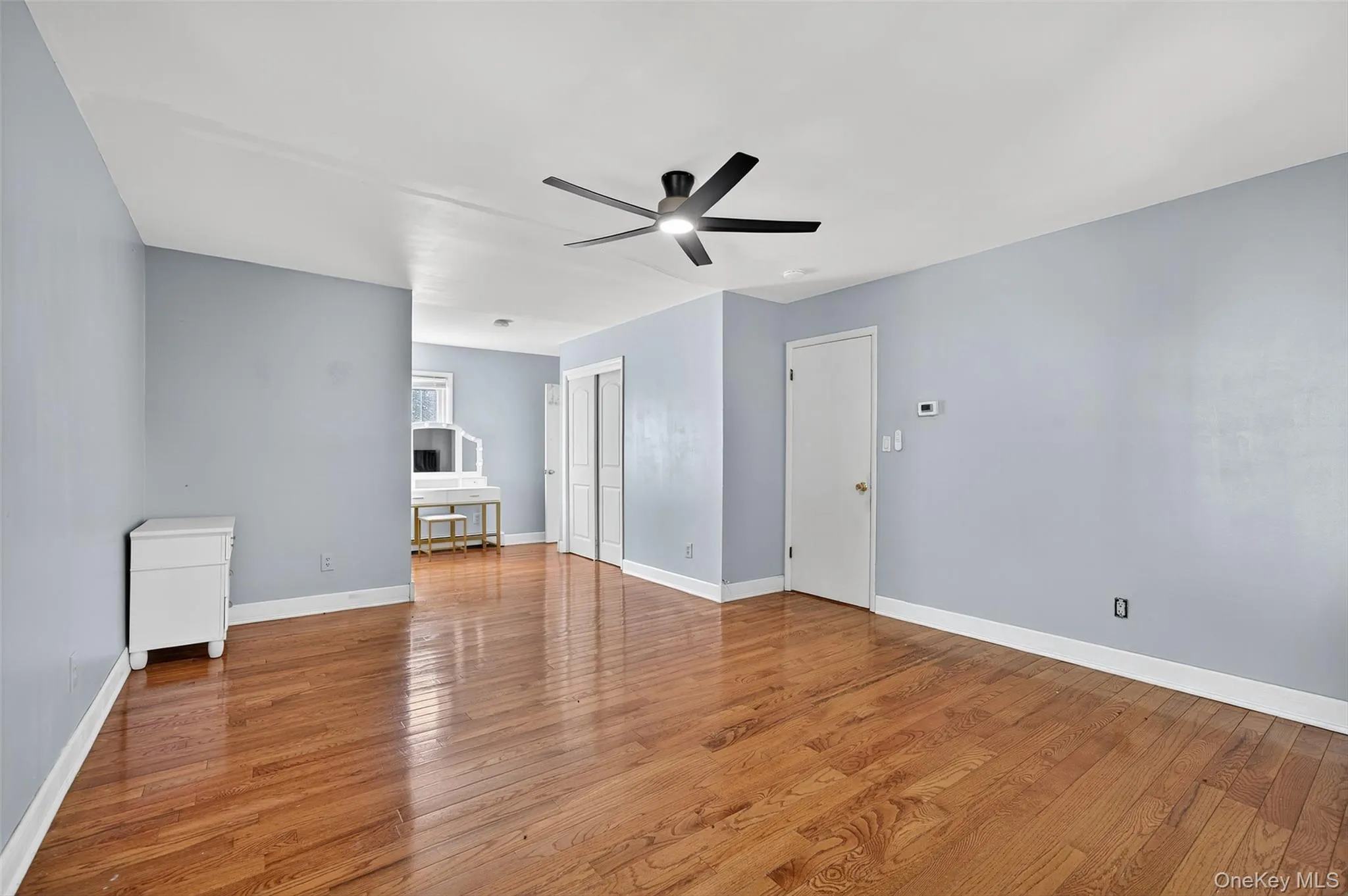 Unfurnished living room featuring wood finished floors and ceiling fan Unfurnished living room featuring wood finished floors and ceiling fan