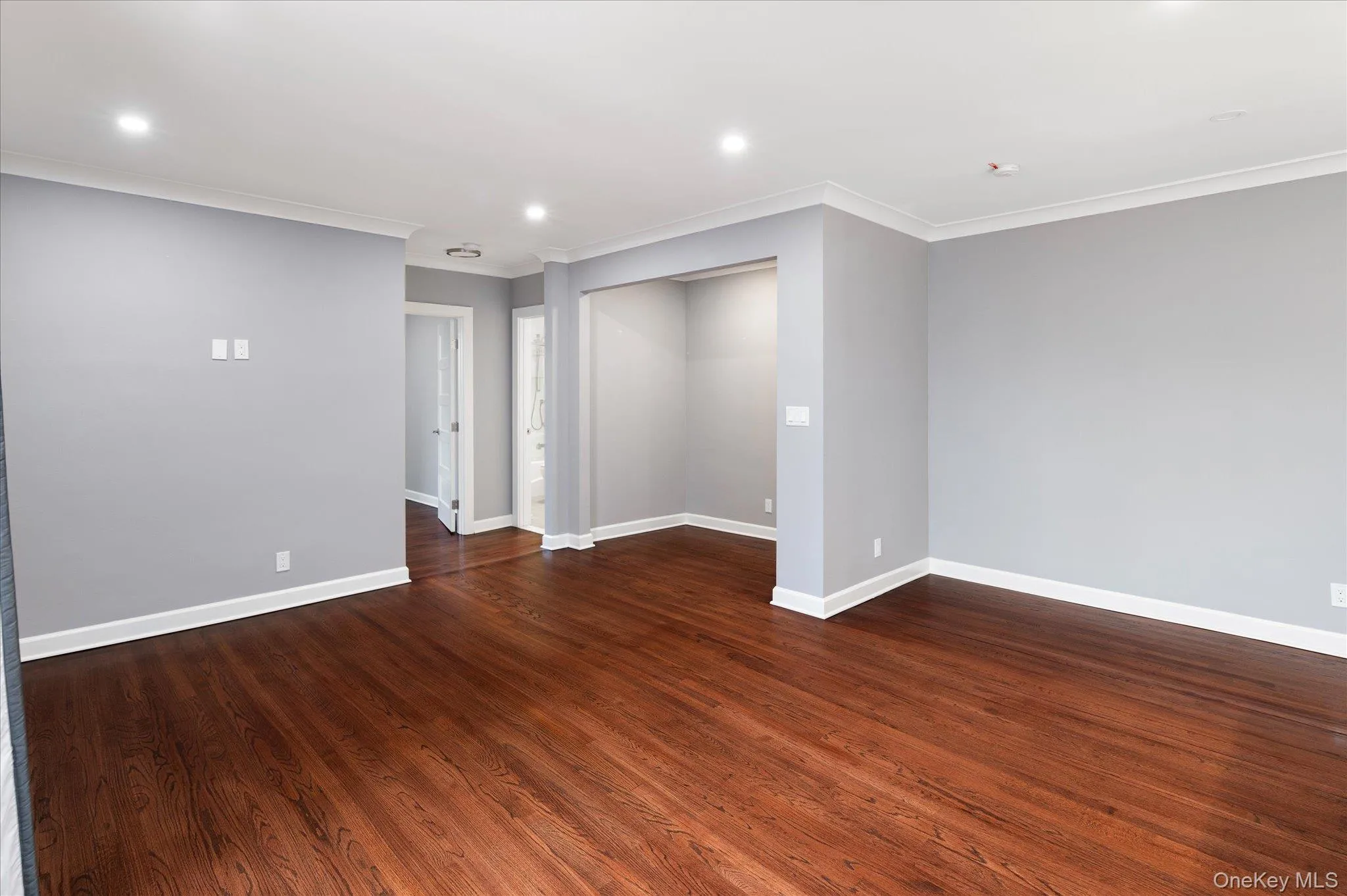Unfurnished room featuring recessed lighting, dark wood-style floors, and ornamental molding Unfurnished room featuring recessed lighting, dark wood-style floors, and ornamental molding