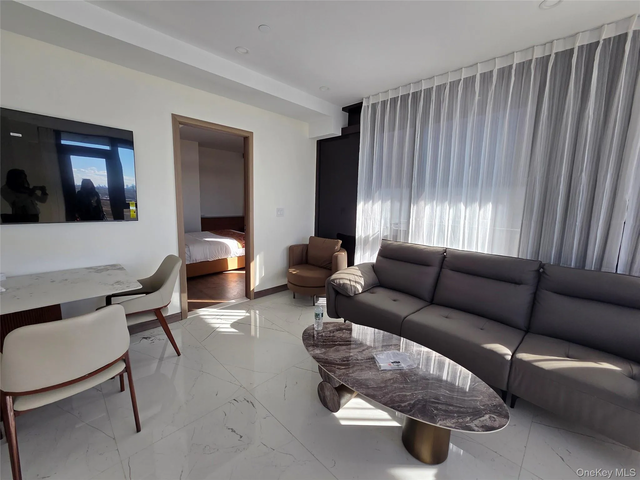 Living area featuring light marble finish floors and healthy amount of natural light Living area featuring light marble finish floors and healthy amount of natural light
