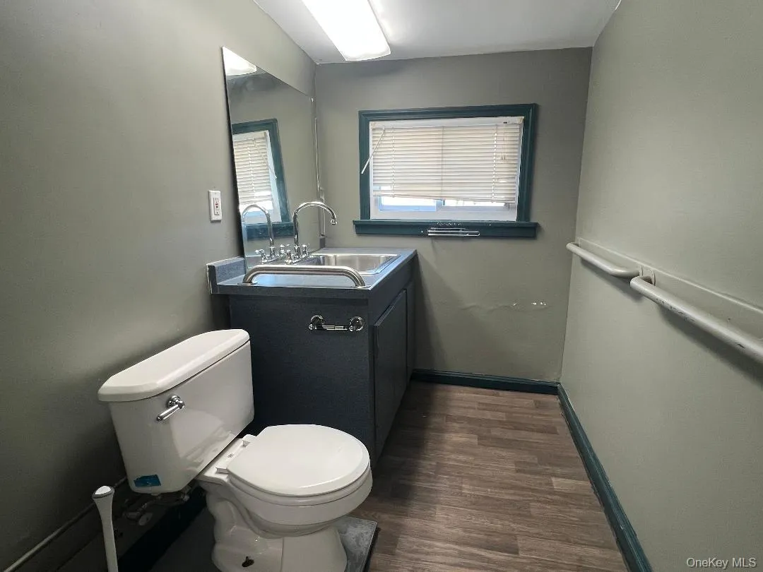 Half bathroom featuring vanity and dark wood finished floors Half bathroom featuring vanity and dark wood finished floors