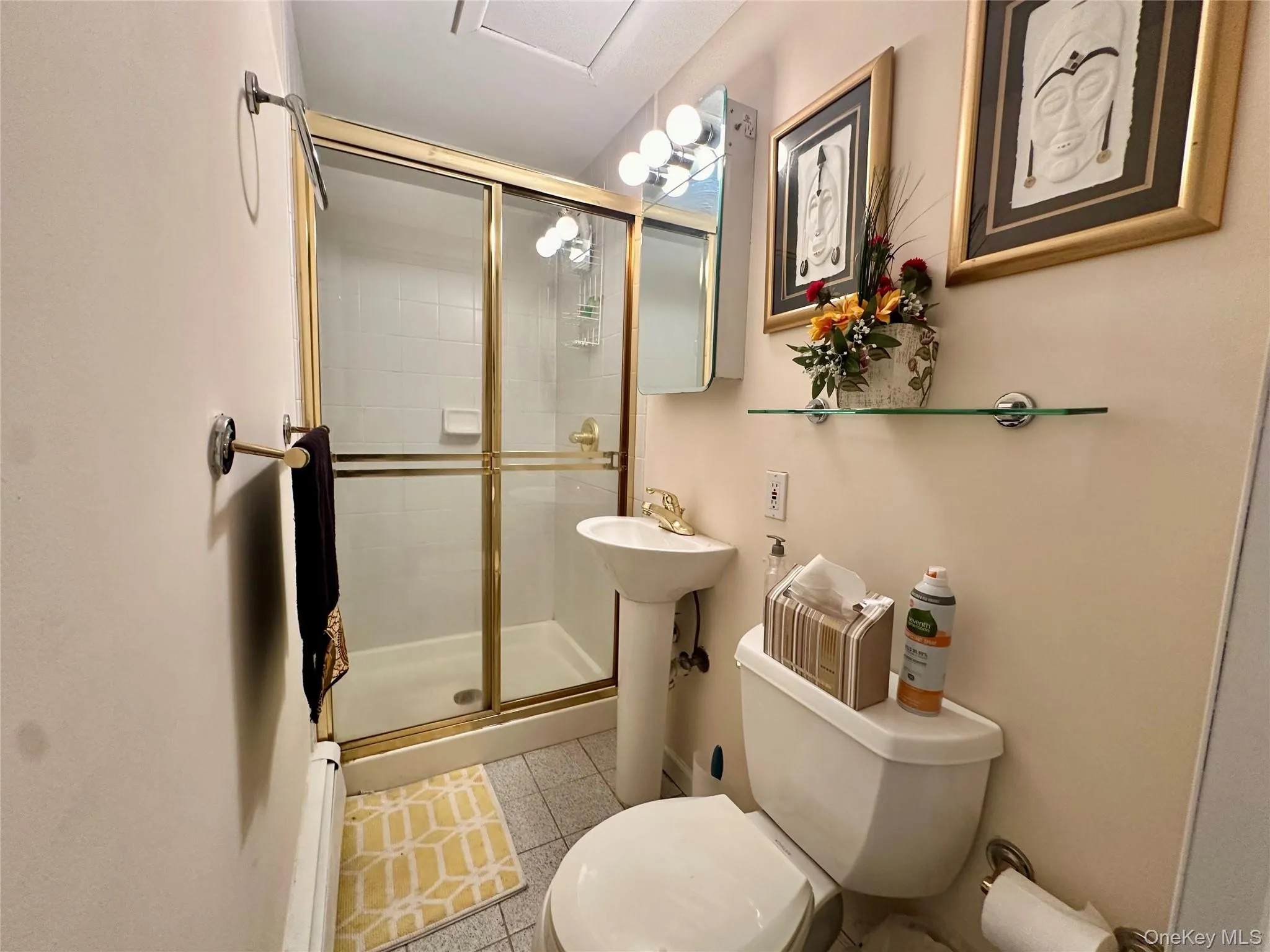 Bathroom featuring light tile patterned floors, a stall shower, and a baseboard radiator Bathroom featuring light tile patterned floors, a stall shower, and a baseboard radiator