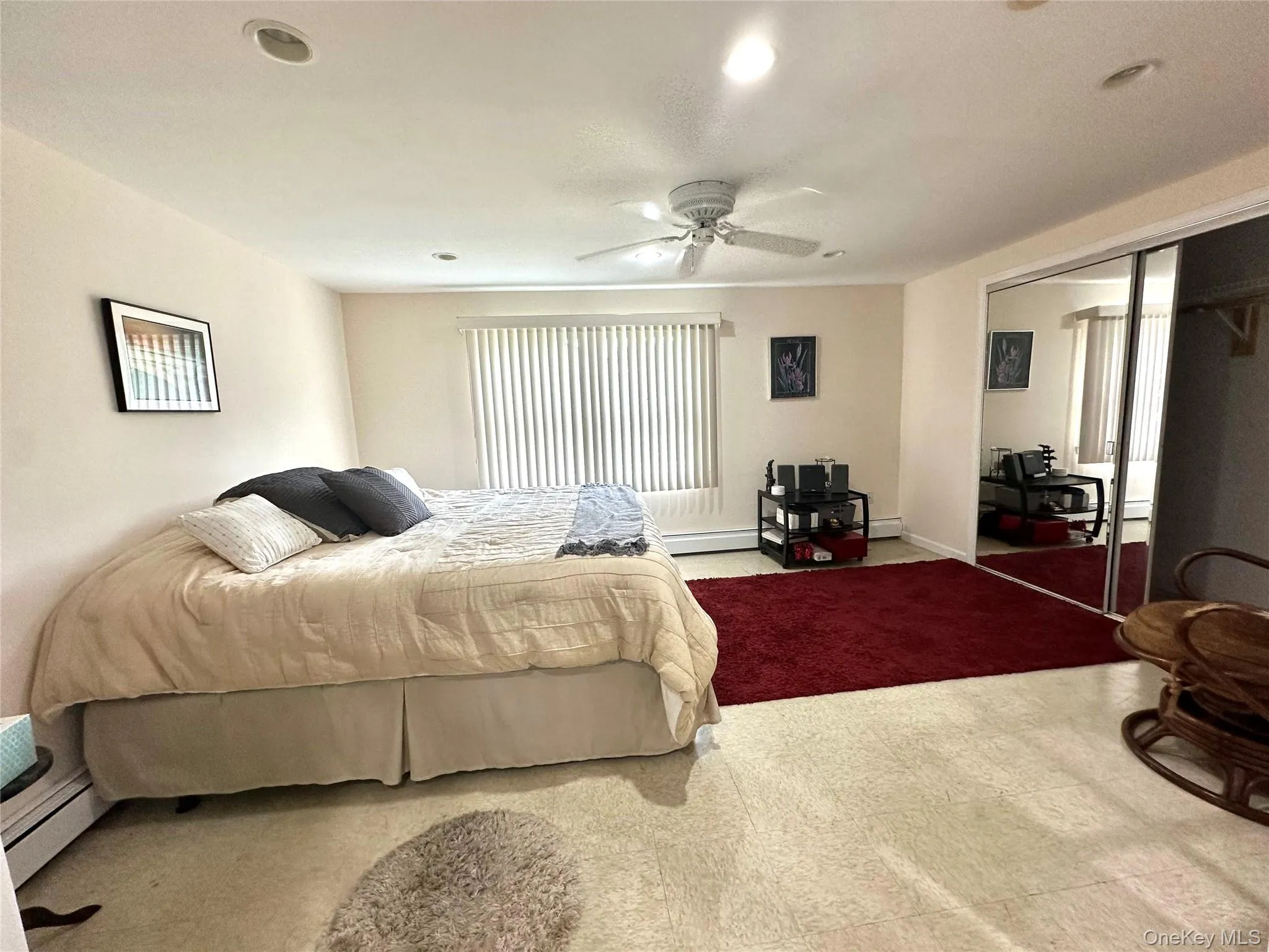 Carpeted bedroom with a closet, a ceiling fan, a baseboard radiator, and recessed lighting Carpeted bedroom with a closet, a ceiling fan, a baseboard radiator, and recessed lighting