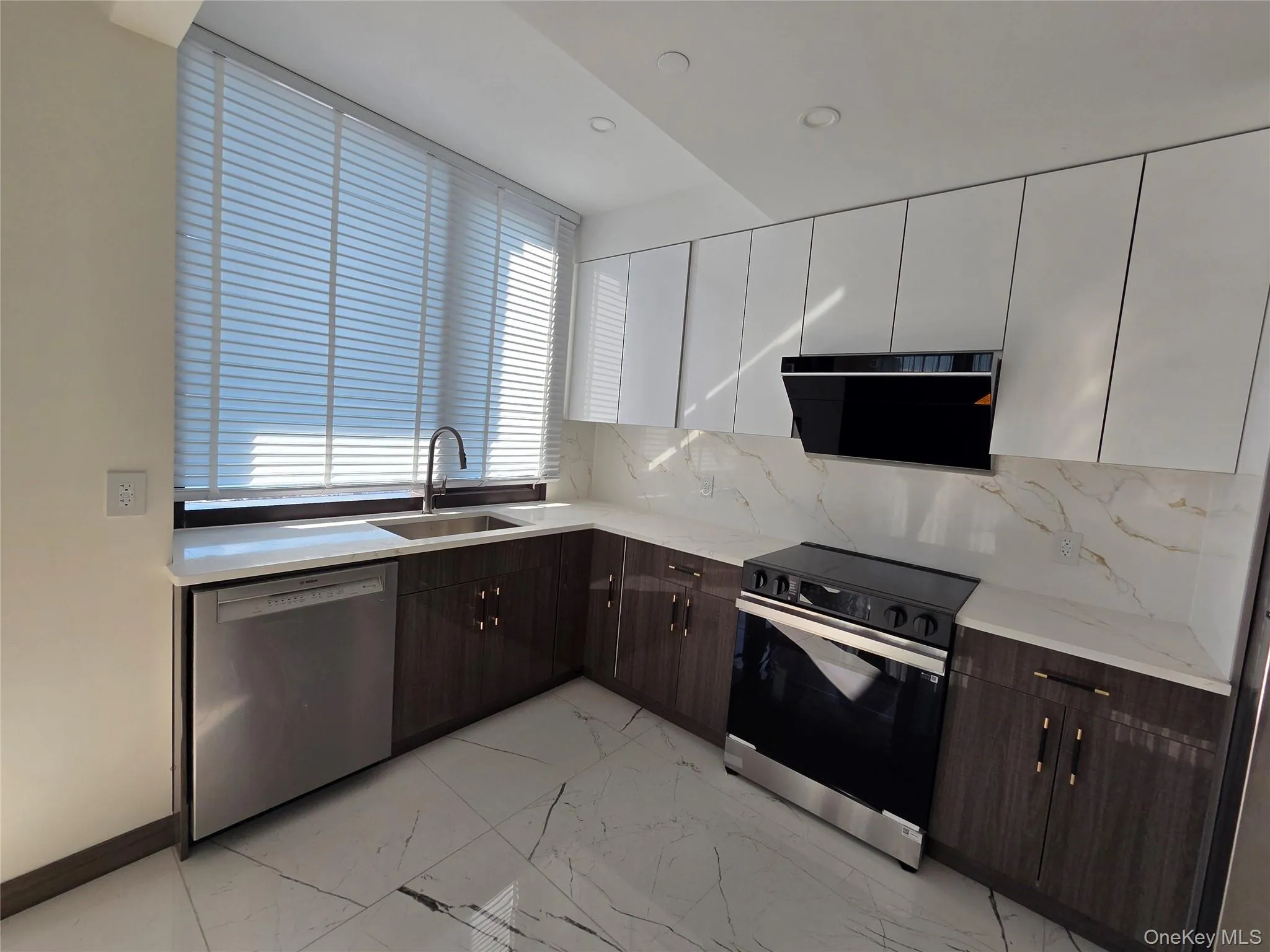 Kitchen featuring tasteful backsplash, modern cabinets, electric range oven, dark brown cabinetry, and recessed lighting Kitchen featuring tasteful backsplash, modern cabinets, electric range oven, dark brown cabinetry, and recessed lighting