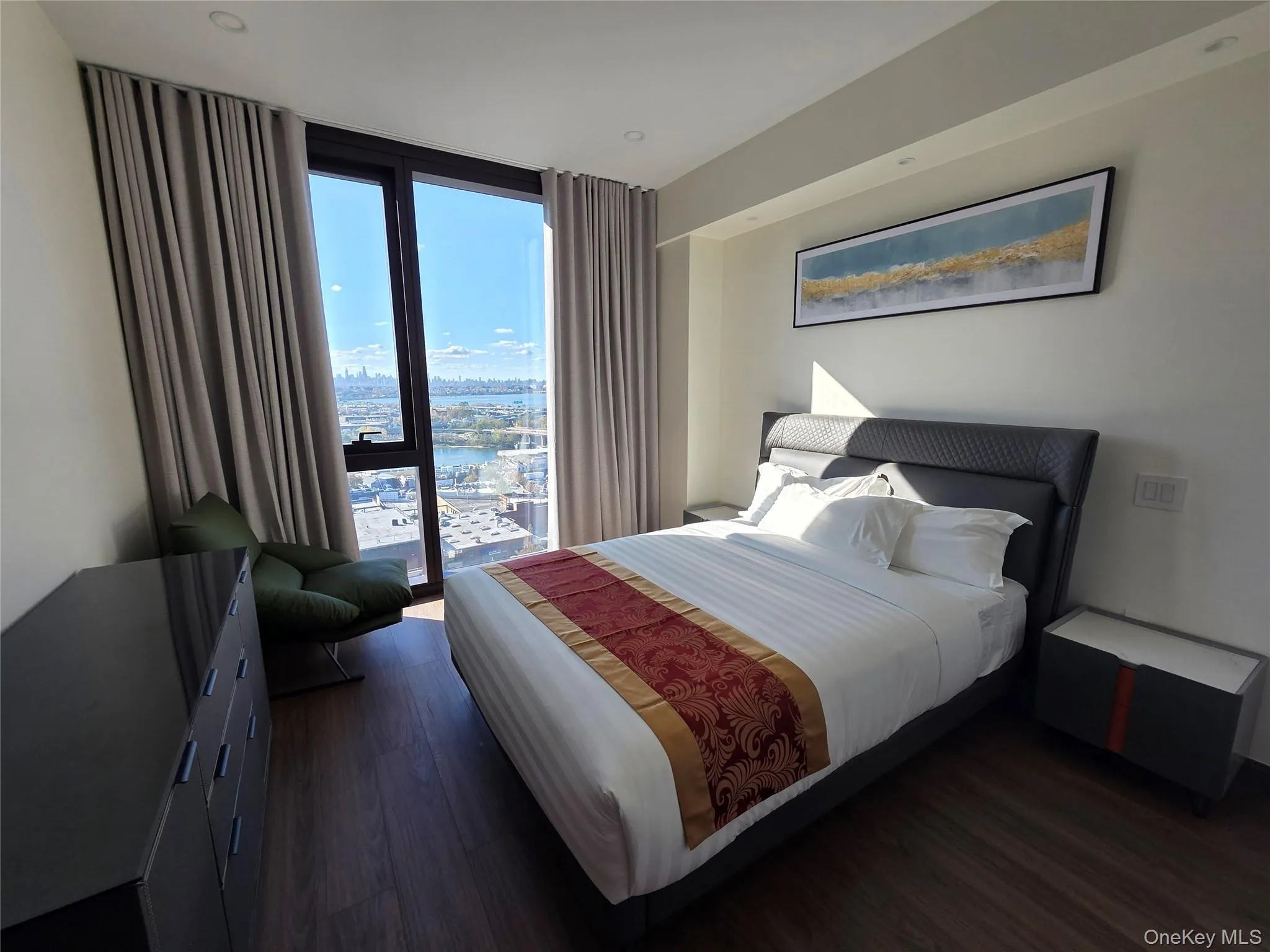 Bedroom with expansive windows, dark wood finished floors, a water view, and a view of city Bedroom with expansive windows, dark wood finished floors, a water view, and a view of city