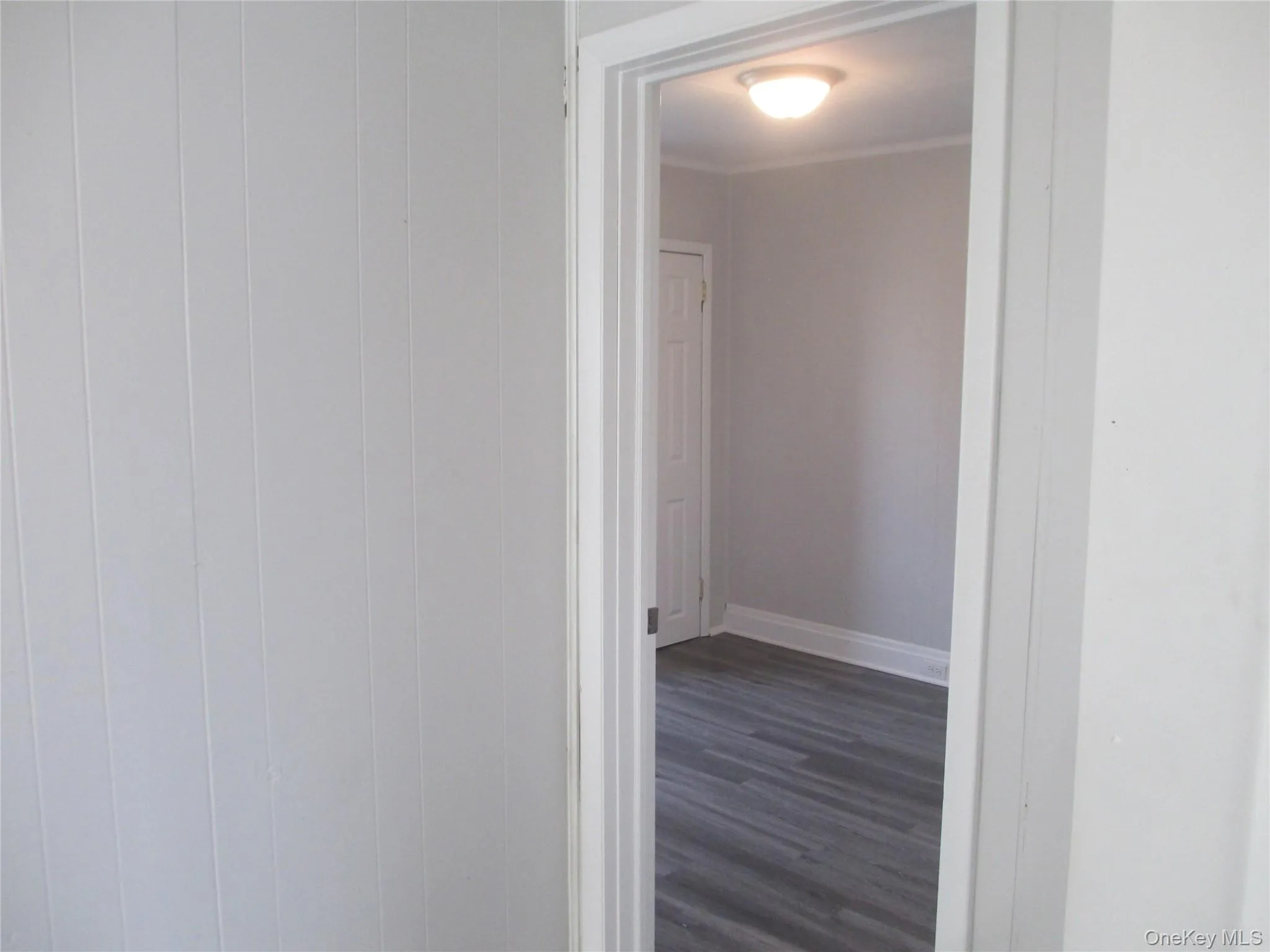 Hallway featuring dark wood-style flooring and baseboards Hallway featuring dark wood-style flooring and baseboards