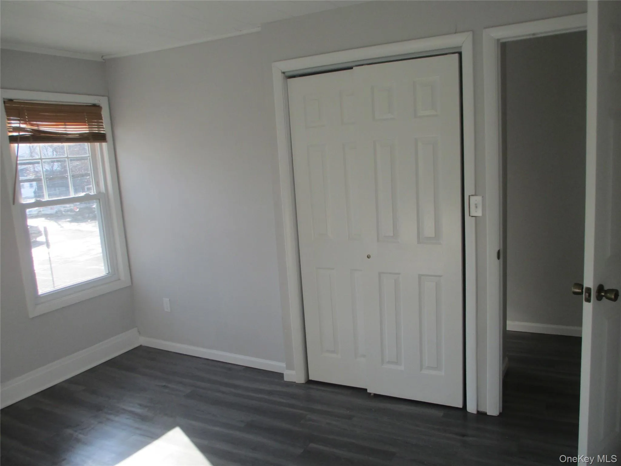 Unfurnished bedroom with dark wood finished floors and a closet Unfurnished bedroom with dark wood finished floors and a closet