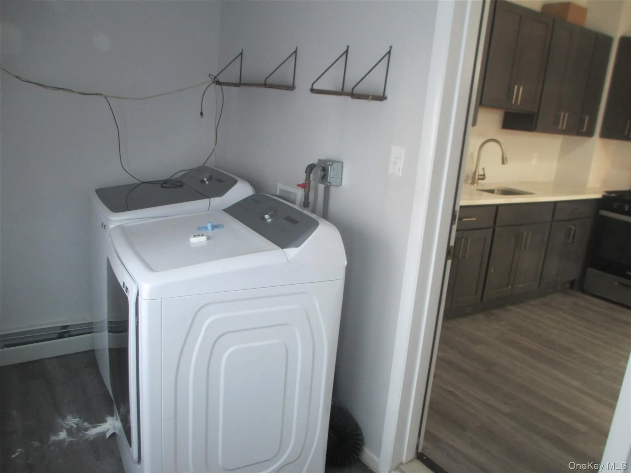 Laundry room with dark wood finished floors and washer and dryer Laundry room with dark wood finished floors and washer and dryer
