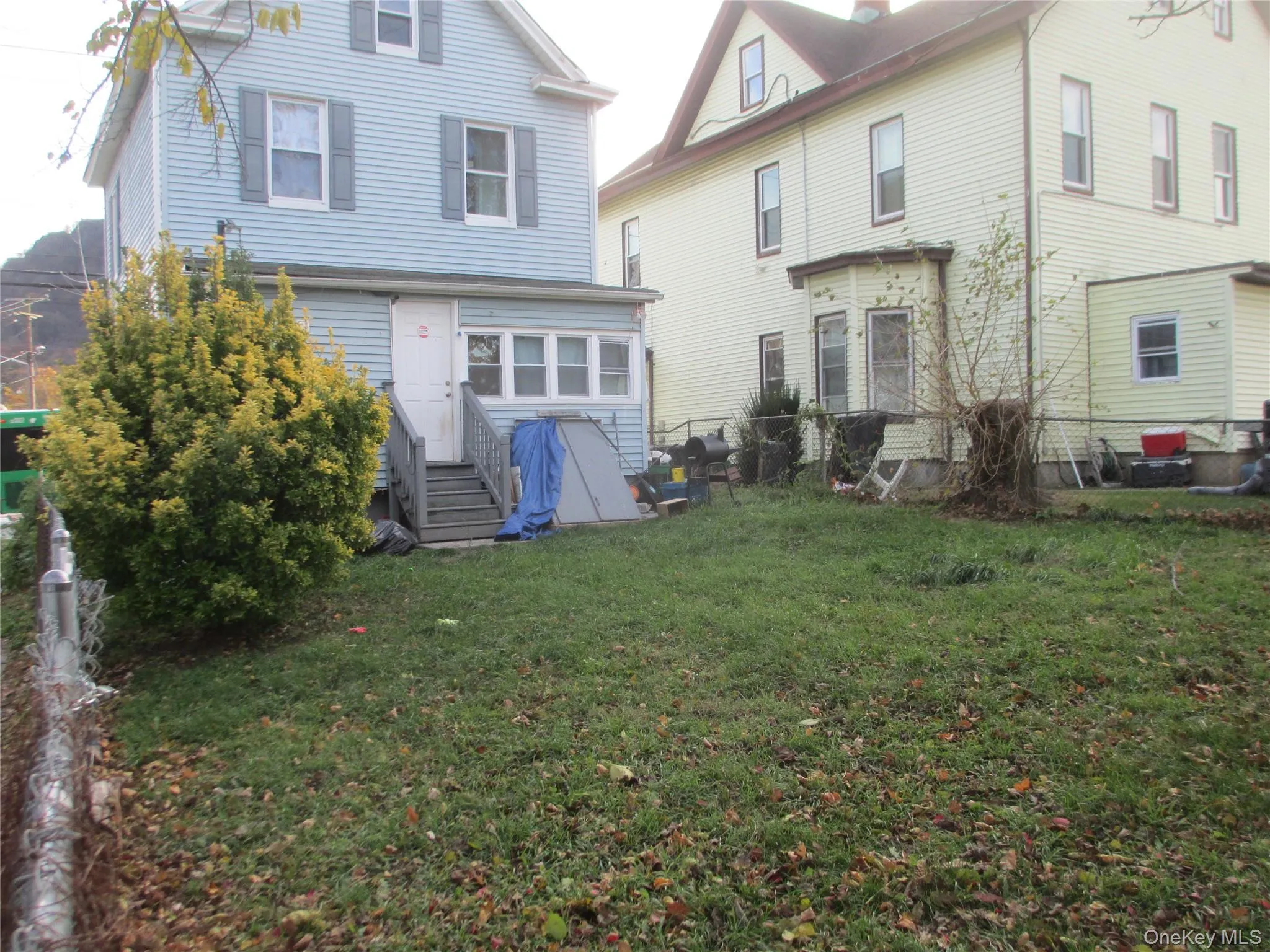 Back of property featuring a lawn and entry steps Back of property featuring a lawn and entry steps